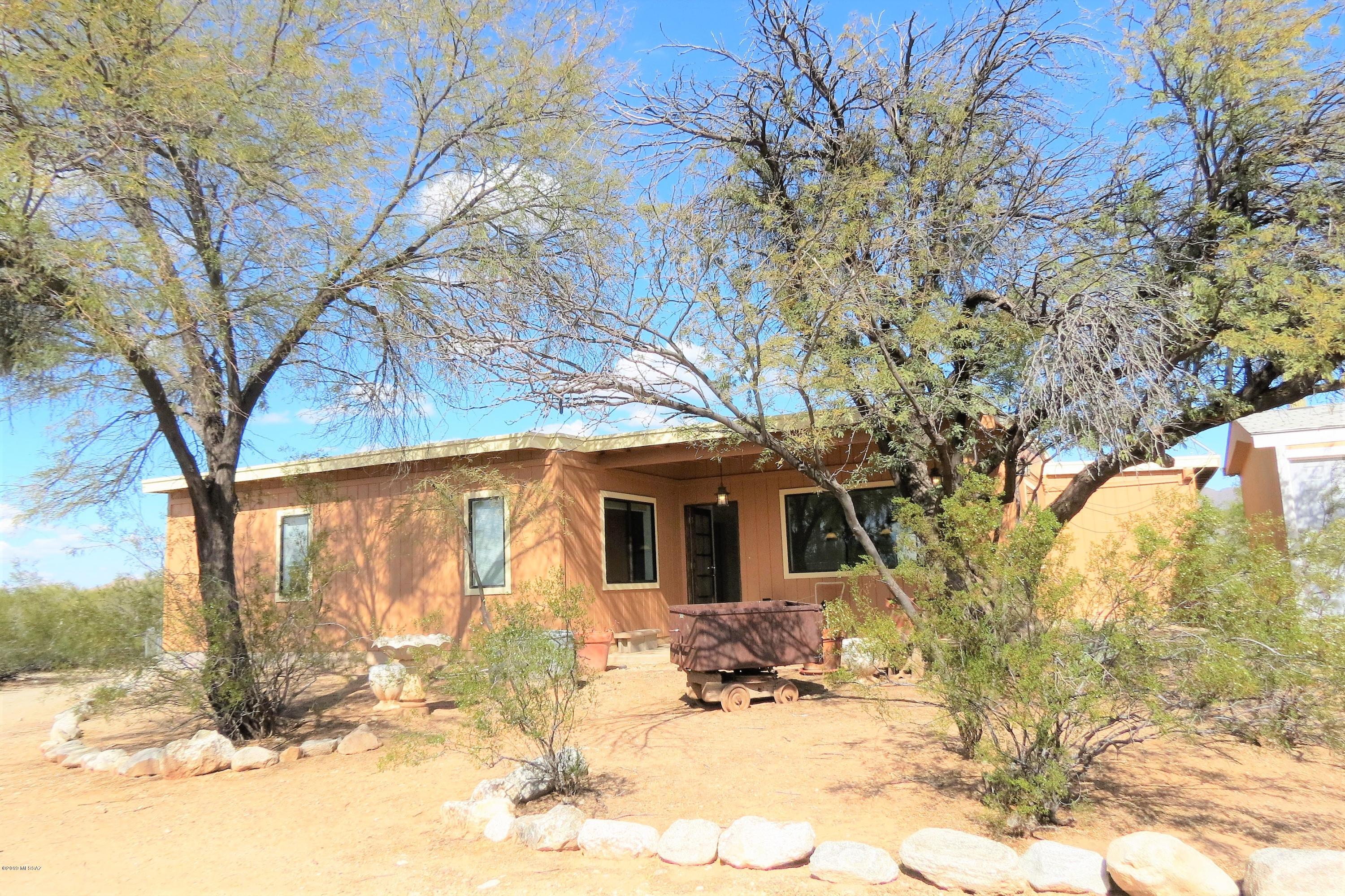 This 2,132 sq. foot home built in 2006 is located at the very end of the road that backs up to the Tucson mountains with unlimited trails right from the property to ride. One acre that feels like more with horse facilities, electric front access gate, circular driveway, RV hook up, storage sheds and work shed. Front & rear covered patios with endless mountain views! New interior/exterior paint. All dual pane windows. Huge tiled great room with double doors to patio. Separate tiled game room/office. Kitchen with lots of natural light, granite counters &  roll out drawers. Refrigerator, washer & dryer stay. Pool table can stay.  2 large bedrooms/2 full baths. Master bedroom has new carpet, walk in closet and side yard access door.