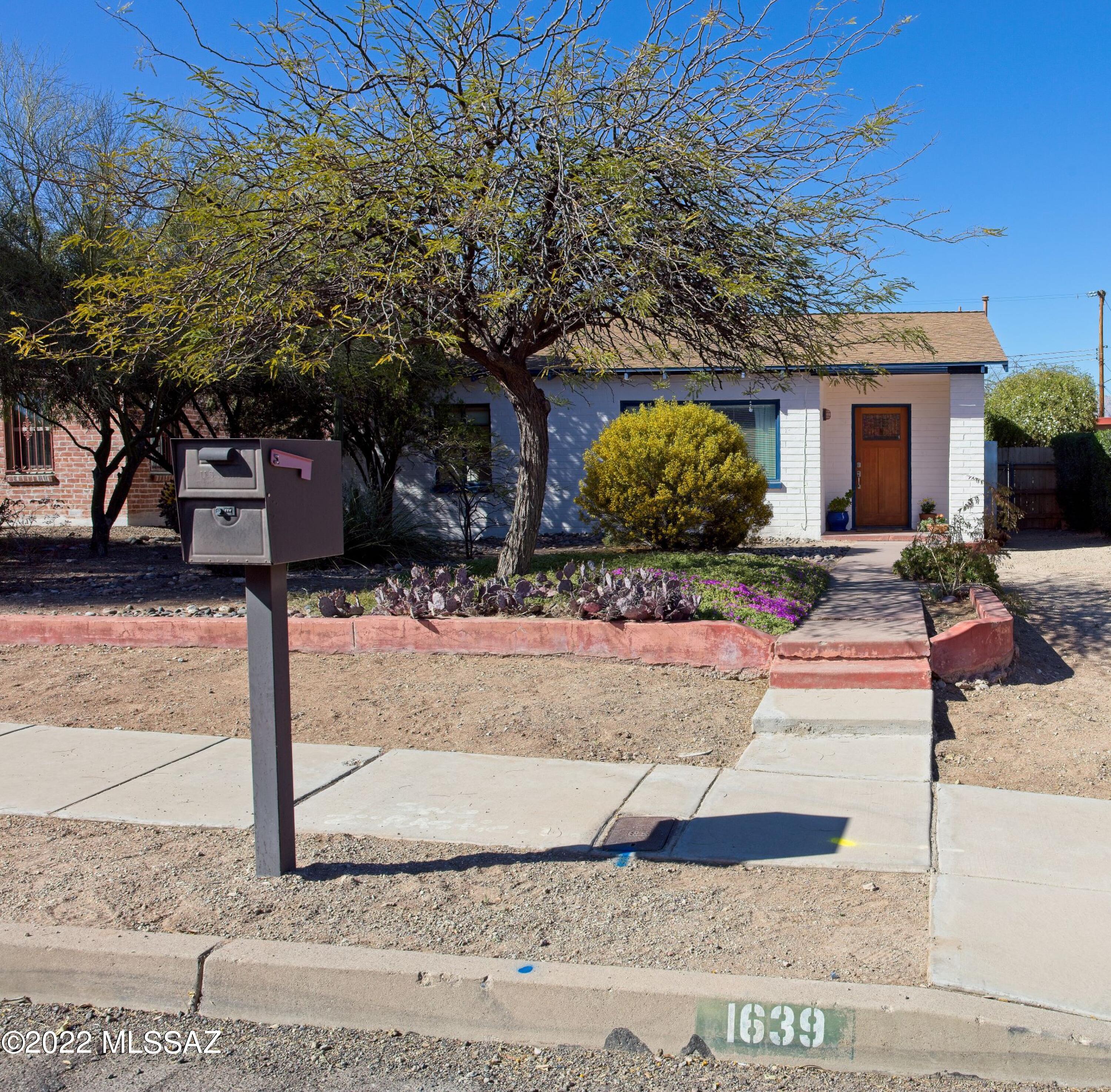 Comfy Mid-Century Bungalow. 2BR/1BA Plus a large AZ-room for office or 3rd bedroom. Built-in book shelves. Spacious living and dining area with engineered hardwood floors. Beautiful lush back yard with mature planting to include pomegranate tree,  tombstone rose bush and more. Off street front parking plus additional back parking. Newer dishwasher, and water heater. Laundry area inside. Large detached storage shed. Main water line from the street has been replaced.Minutes from Banner Medical, U of A, Campbell Corridor Shopping and Dining.