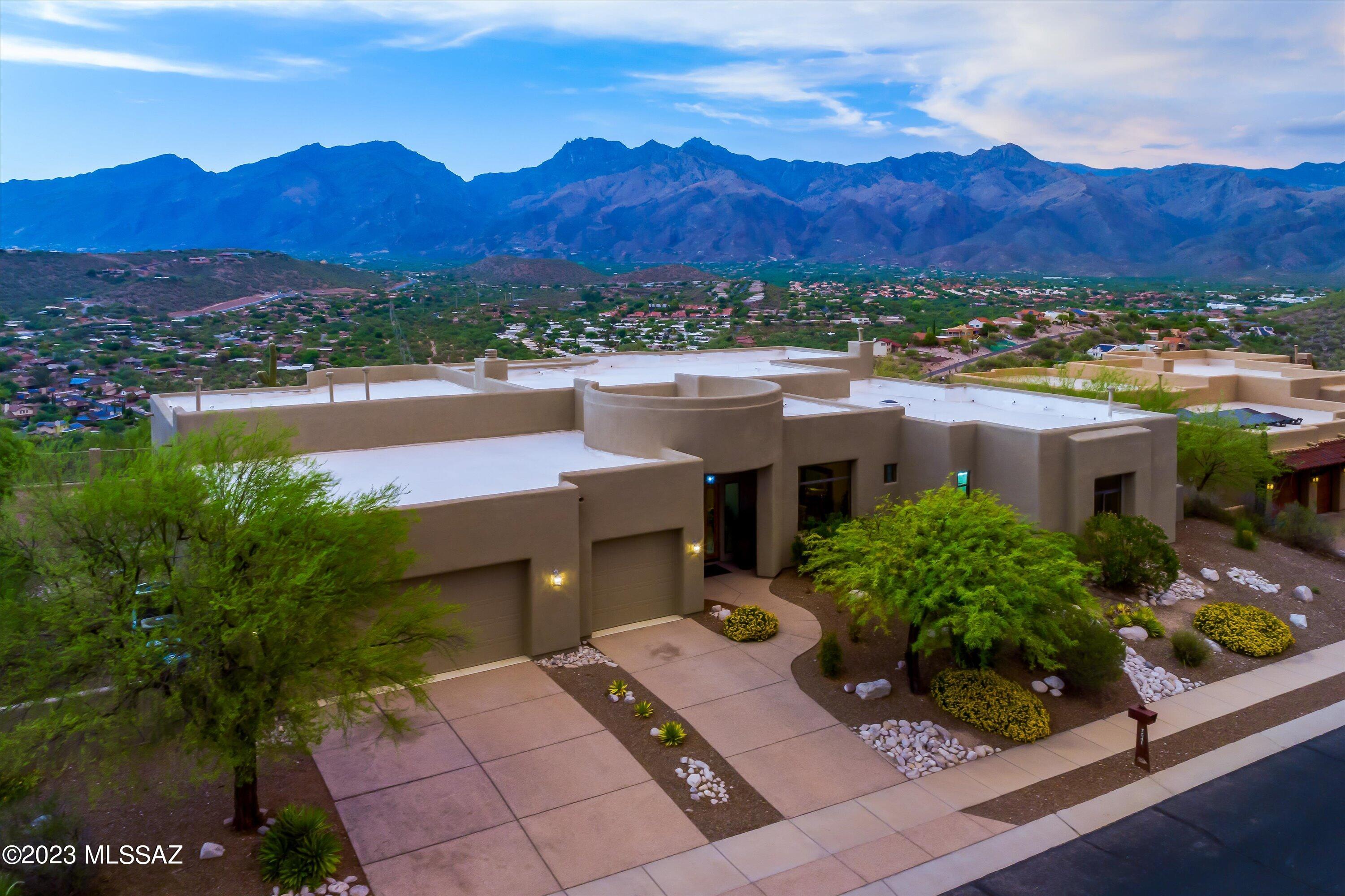 Introducing an exquisite home with breathtaking views of mountains and city lights. Nestled in the exclusive gated ridge of Sabino Mountain, offering unmatched luxury & privacy. Open layout boasts walls of windows, filling the home with natural light and showcasing mesmerizing vistas. Expansive ceilings, large spaces and a chef's kitchen is an entertainer's dream. Step outside to the covered patio immersing yourself in the serene surroundings. Adorned with stunning quartzite floors, soft colors this home exudes elegance. Grand primary suite with laundry, beverage fridge, luxurious bath with dual closets, spa, walk-in shower finished stunning natural stone. Beautiful fireplaces enhance the warm and inviting ambiance. Discover the pinnacle of luxury living in this exceptional home.