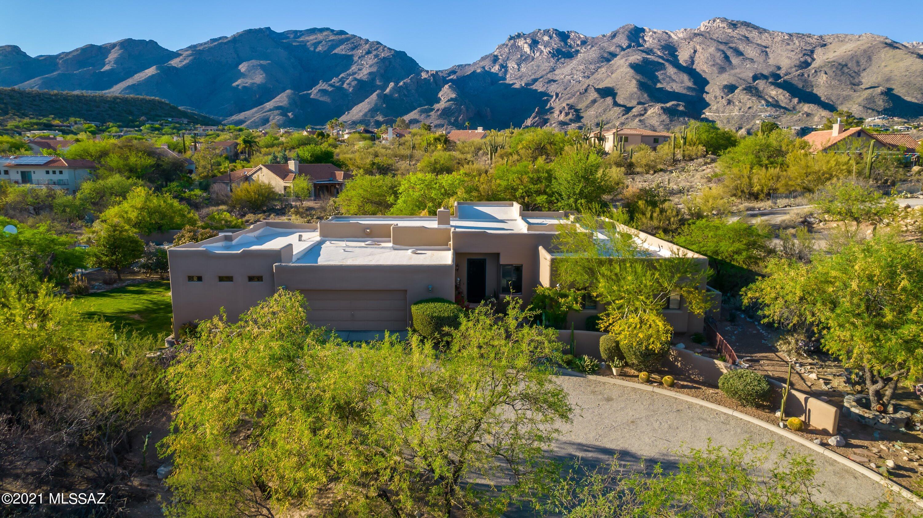 Rare opportunity for a home on almost an acre of flat land in the highly desirable Cimarron Estates. AT 4,000s/f +, this 4 bed/4 bath beauty has a family room, living room, breakfast nook, formal dining area, and office w/ built-ins. Tons of storage in the oversized laundry room and a kitchen big enough to entertain friends and family. High Ceilings and contemporary feel. Private yard w/ spectacular mountain views. The outdoor space is one of a kind and all gated in. Covered patio and enormous grass area perfect for kids or pets, outdoor chimenea, tranquil fountain, basketball court, pool and spa with breath-taking views of the mountains. Great mature landscaping makes for lush escape in your own backyard. Close to Sabino Canyon, dining/shopping, and schools. This is a must see!