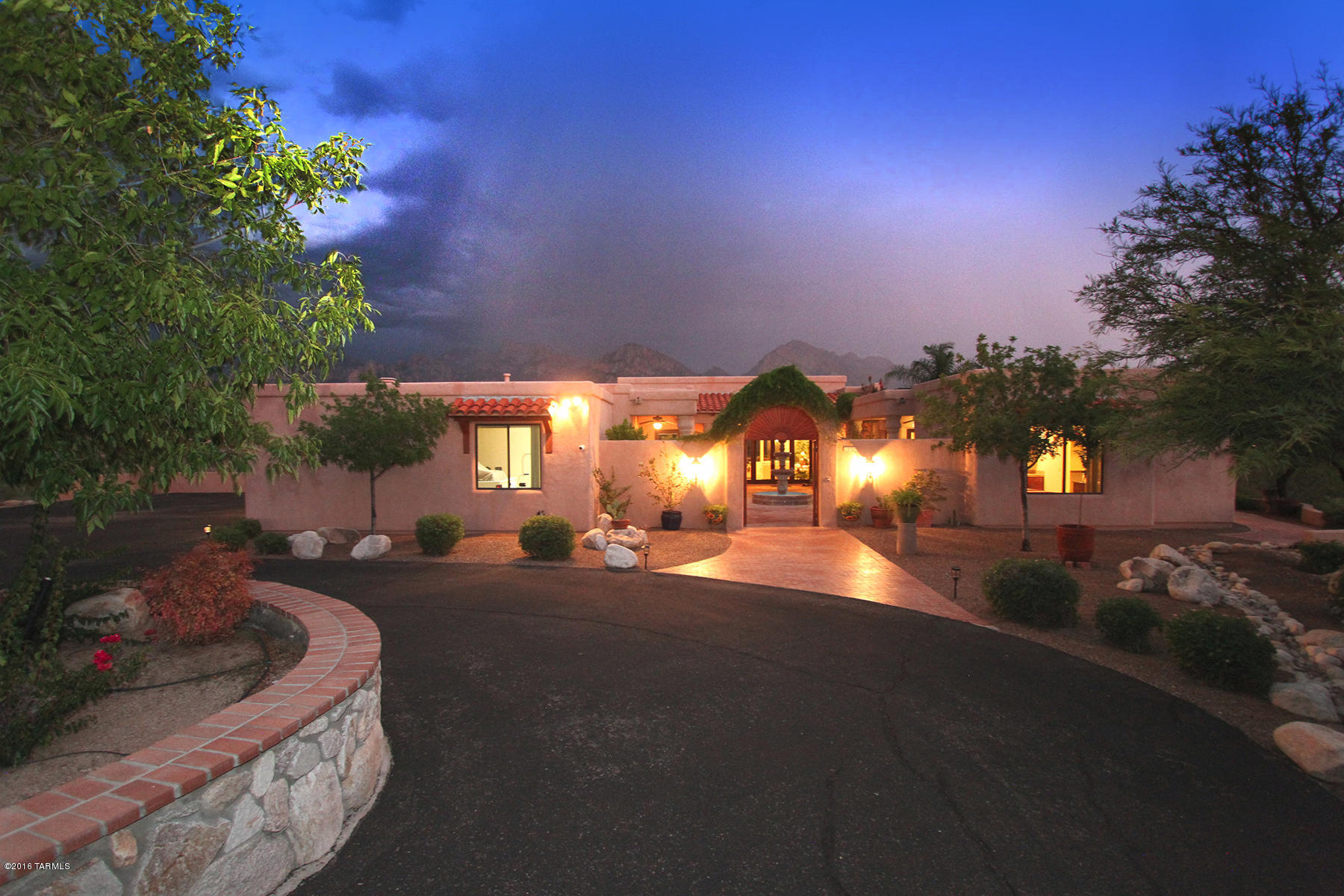 Hidden Treasure in Oro Valley! A private enclave up a hidden gated drive with in-your-face views of Pusch Ridge from nearly all rooms, custom designed with love by the original owners/sellers and perfect for the most discriminating buyers. Through massive wooden gates find a lushly landscaped traditional Colonial Mexican style courtyard with gardens, pavers, carved Cantera columns, a flowing fountain, an original tile mural, fans in covered areas, and surround sound for possibly an elegant presentation of a traditional Flamenco or Malaguena dance (a perfect setting).  Enter into the gracious loggia-style entry flanked by arches and richly carved Cantera columns and look beyond the sparkling pool and spa outward through a wall of windows to perfect and forever Pusch Ridge views. ceilings accented with sculptural coffered and custom painted features grace this special home, along with elegant bronze and frosted crystal light features reminiscent of fine Lalique crystal. Custom-painted art niches abound. A gourmet chef's kitchen with cherry-stained alder cabinetry, beautiful granite counters and a generous windowed breakfast area and family room opening to the sweeping terrace provide the center of the home. Rich chocolate-charcoal thick granite counters top all cabinets and the large curved island that is home to a five burner Kitchen-Aid cook top and convenient bar sink with disposal. All appliances are stainless steel Kitchen-Aid, and features include pullout drawers in cabinets, self-closing drawers and a large convenient pantry. The ample breakfast area features curved walls of windows looking out to the jagged peaks of the entire western side of the Catalina Mountain Range as far north as the town of Catalina, a magnificent view for morning coffee with fabulous sunrises. The adjacent family room features a massive fireplace flanked by more Cantera columns, with a broad sittable hearth and a Cantera stone mantle and surround that extends to the high ceiling. A wall of doors leading to the terrace can be opened completely for an indoor-outdoor living experience. A separate bar area with wine refrigerator occupies a corner of the family room, a perfect gathering spot to watch U of A games. A very ample master bedroom suite provides views from the bedroom over the stunning negative edge pool to Pusch Ridge and up the entire Catalina Mountain Range north and south. Softly lit by hidden lighting in the custom painted recessed ceiling feature, this is an amazingly romantic setting. A large master bath provides a Jacuzzi tub with views of city lights and yet total privacy (bring on that glass of perfectly chilled Chardonnayâ"or is that better in the outdoor spa or on the pool's built-in seats facing the mountains? Tough choice!) along with separate lavatory counters, a seated make-up area with built-in magnifying mirror, separate walk-in shower and commode, and ample walk-in closet. Two additional bedrooms plus a large casita with its' own entrance and new under-counter refrigerator also enjoy marvelous views.  Another bedroom or office looks out to the courtyard. A fabulous outdoor area provides a negative edge pool with two stone water features, pool, spa and generous entertaining spaces. A large area on the south side of this amazing home has statuesque palm trees and a grassy area that could be a fabulous putting green. This is a home with heart and soul, nothing cookie-cutter here. The owners personally selected all of the Cantera stone in the home from a quarry in Cucurpe, Sonora Mexico, had the columns carved in nearby Imuris, Sonora, drove it to the home site and personally raised the Cantera columns on the exterior of the home. The stones and boulders forming the pool's lovely water features were also personally selected and placed by the owners. The home overlooks a wash providing total privacy in all directions. It's a gorgeous spot to watch the monsoons roll in over the mountaintops or 4th of July fireworks or the moon rising. This is a home that radiates warmth and graciousness, it's elegant yet comfortable for today's casual lifestyle and a one-of-a-kind opportunity in Tucson homes. This is a home for discriminating buyers that want ultimate privacy with hardly any neighbors. This is not a large subdivision like Stone Canyon or Honey Bee Subdivision. Spoil yourself and take a look!!