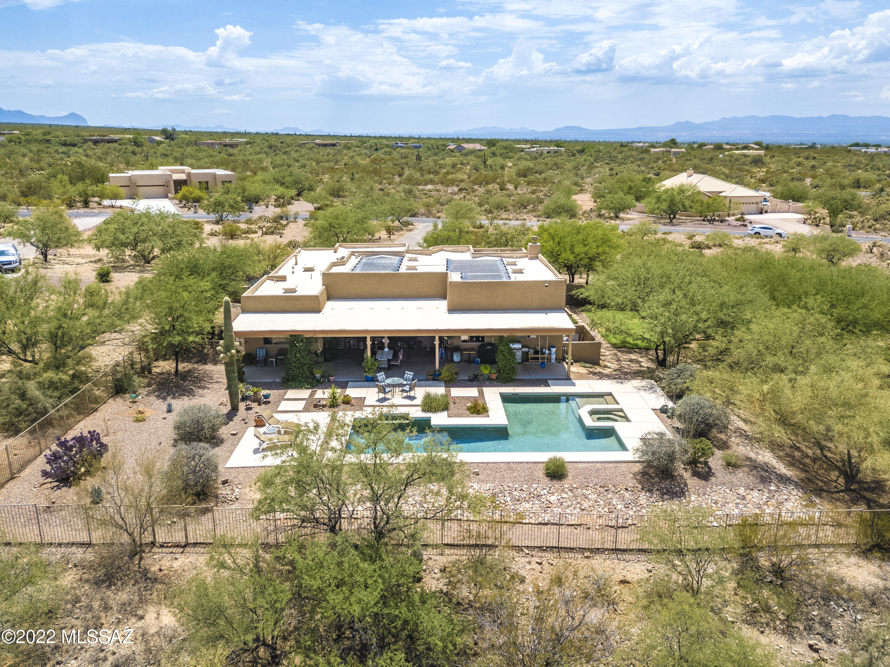 Stunning desert living is yours to enjoy from this gorgeous Santa Fe home on over 2 acres in peaceful gated Sycamore Hills estates. Enter the front custom mesquite door to the dramatic open floor plan with 12 ft ceilings and view to yard oasis.  A chief's dream kitchen with granite island, custom hickory cabinetry and plenty of storage with a double oven.  This 4 bedroom 3 bath has many upgrades including brand new dual pane low E Pella windows with 8' patio doors and new ceiling fans and led lights throughout.  New water heater and roof coating and new bosch dishwasher in 2019,  The three car garage with led lighting and new garage doors could house a great work shop.  Super fast internet. Relax, entertain on the large covered patio overlooking the amazing custom solar heated pebble tech pool with 40 foot lap area and lagoon area including a bubbling spa! City lights and mountain views, pure tranquility!  Come see your next home.