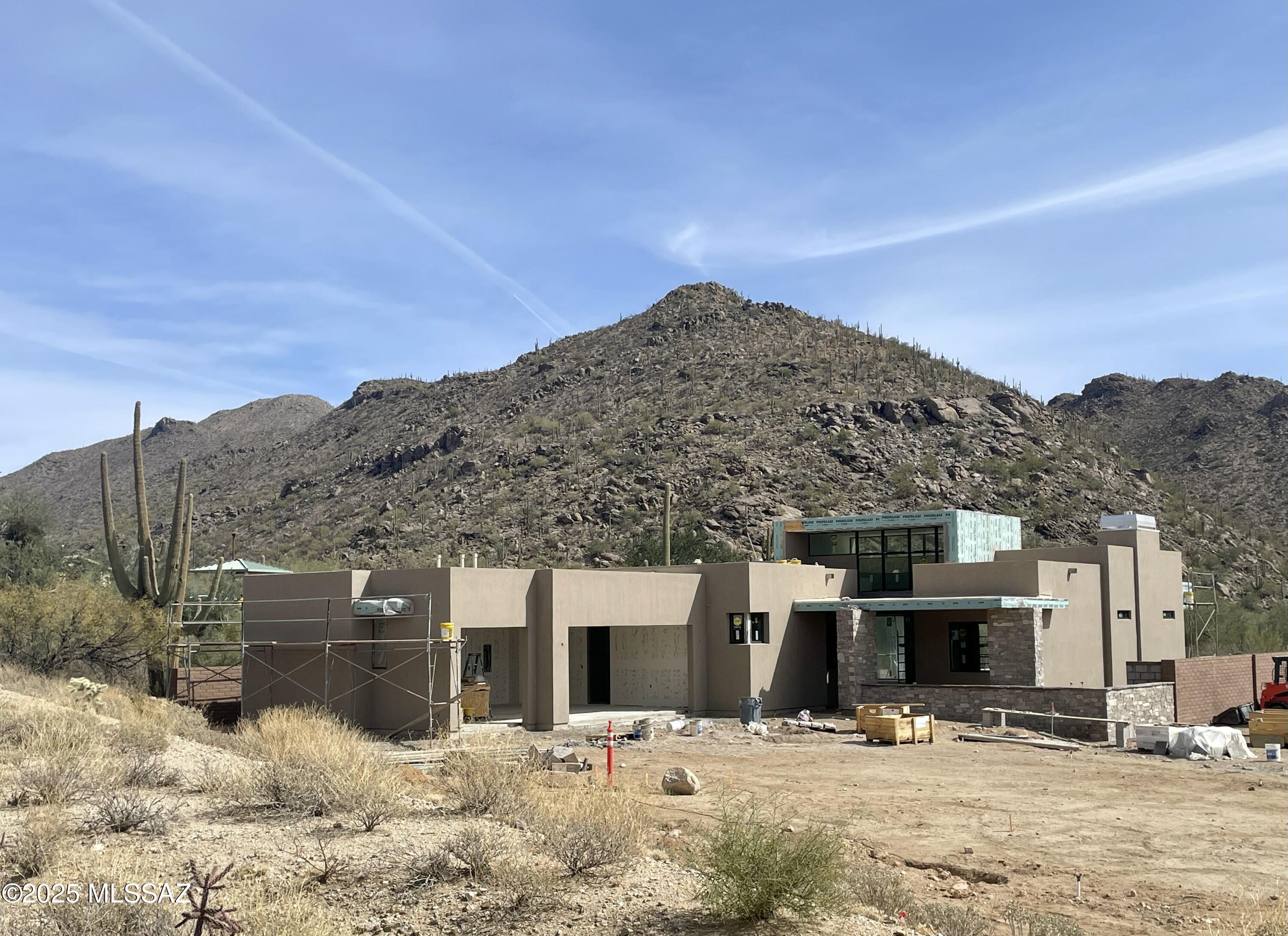 Beautiful Modern Adobe within the gates of The Ritz-Carlton Residences, Dove Mountain. Owners enjoy access to Ritz-Carlton Resort Amenities, Concierge Services, social events and more. 
Enter through a gracious courtyard, showcasing a custom steel entry door and enjoy stunning views of the mountains just beyond your pool and spill-over spa. This home features neutral, designer finishes throughout, including Sub-Zero and Wolf Appliances, natural stone, a chic gas fireplace and more. This private homesite is situated walking distance to the Resort and hiking trails in the newest Ritz-Carlton Neighborhood- Coquillo.