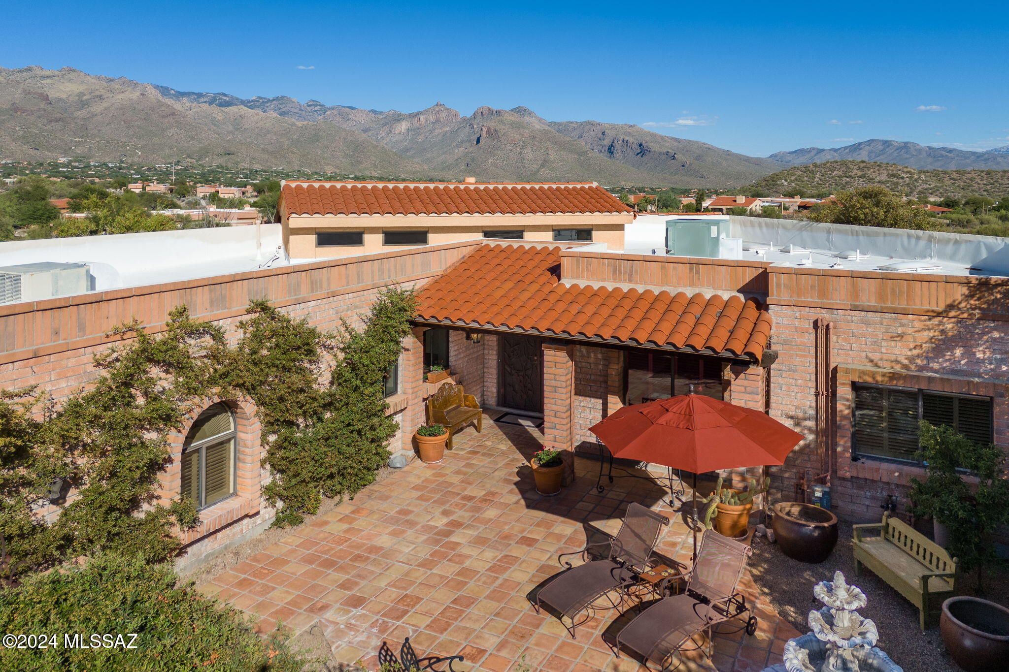 Perched high on the ridge in Fairfield in the Foothills on an exceptional mountain view lot. This beautiful home features 2BR plus large Study that evokes a true Tucson Hacienda. Enter through the stunning gated entry courtyard with saltillo pavers, elegant fountain welcoming you inside showcasing the beautiful living room w high ceilings, warm fireplace and magnificent mountain views. Stunning island kitchen wViking appliances, gas range, second oven, warming drawer. Charming separate dining and living room feature beamed vaulted ceiling accented  by natural light. The primary suite features stunning remodeled bath and custom walk in closet. Spacious guest bedroom also features walk in closet. Large den/study can also be used as guest BR. Exquisite back entertaining pool and patio area are not to be rivaled.  Deep covered patio, wonderfully designed pool and spa with elevated patio. Panoramic mountain views that don't stop.  An entertaining showplace.