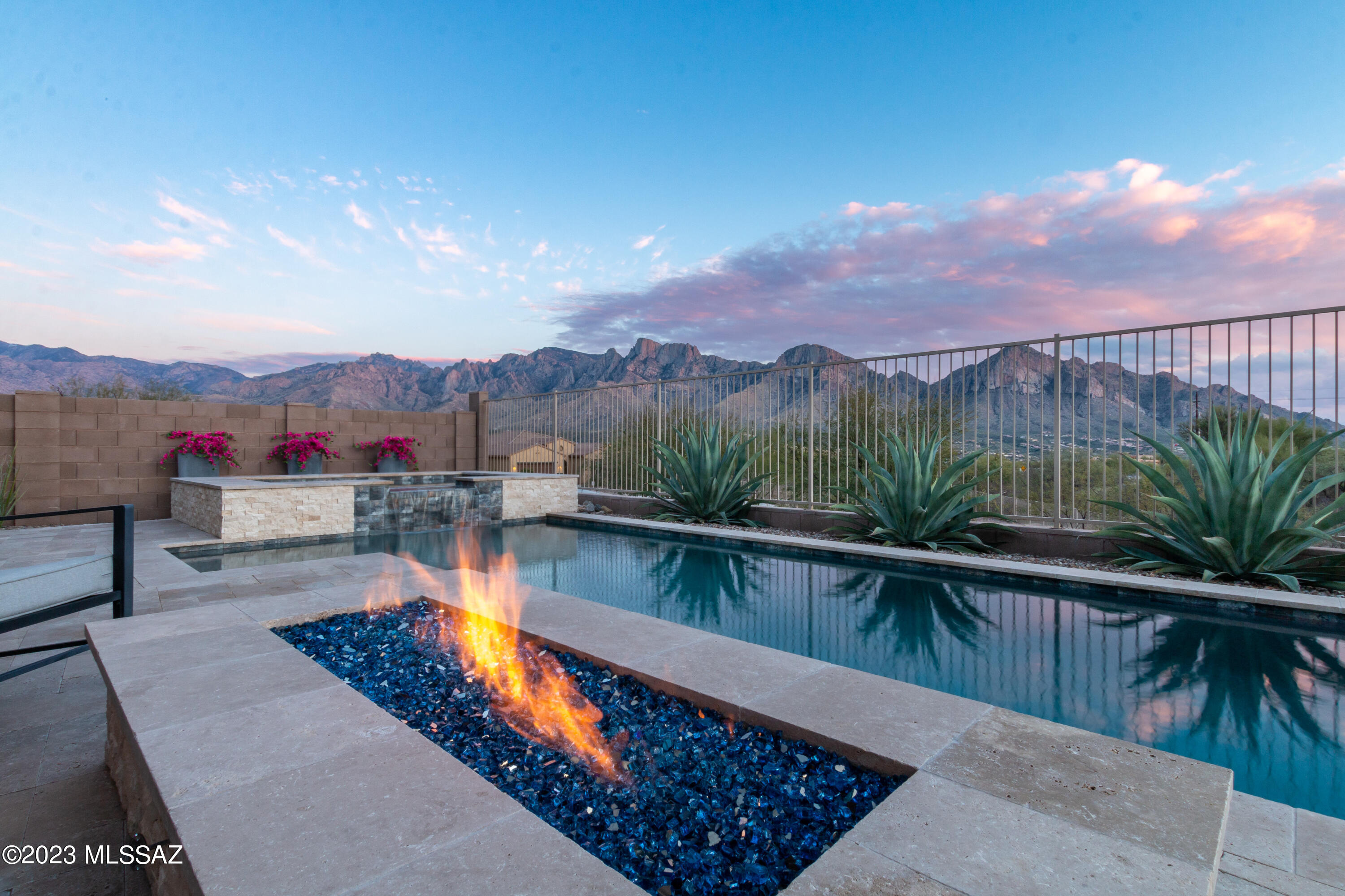 ENTERTAINING RESORT STYLE PARADISE with BREATHTAKING VIEWS!! Welcome home to those incredible views of the Catalina mountains on this premium lot overlooking a desert preserve and
community trail. Enter style and luxury with this Bright, open, split bedroom floorplan that is perfect for every lifestyle. The interior features soaring ceilings, beautiful ceramic wood like tile, chef's dream kitchen with Kitchen Aide stainless steel appliances, granite unpolished counters, tile backsplash, gas cooktop, extended breakfast island, formal dining room, built in custom wine wall with mini fridge and a spacious pantry with plentiful storage.  The 3 guest suites are all sizable with walk in closets and
conveniently located full bath. Then you have a bonus office/den with another upgraded half bath with full tile wall. Even if you have laundry to do you will love this custom designer space with upgraded cabinets, granite, tile walls, and sink and to get the choirs done. When you are ready to enter your sanctuary the luxurious En Suite will sooth you with a relaxing soaking tub, separate shower, and walk-in
closet. Let's not forget to enjoy the resort style paradise backyard with travertine surround, sparkling pool/spa, water feature, cozy glass firepit, and built-in custom-made BBQ area with bar and granite counter. All this creates the perfect atmosphere to entertain or relax to those Stunning Views. The icing on all this is Owned Solar and tandem 3 car garage w/epoxy floors. If you need more this Gated community provides covered ramada's with picnic tables and playgrounds. This one will check every box and is an amazing HOME!!