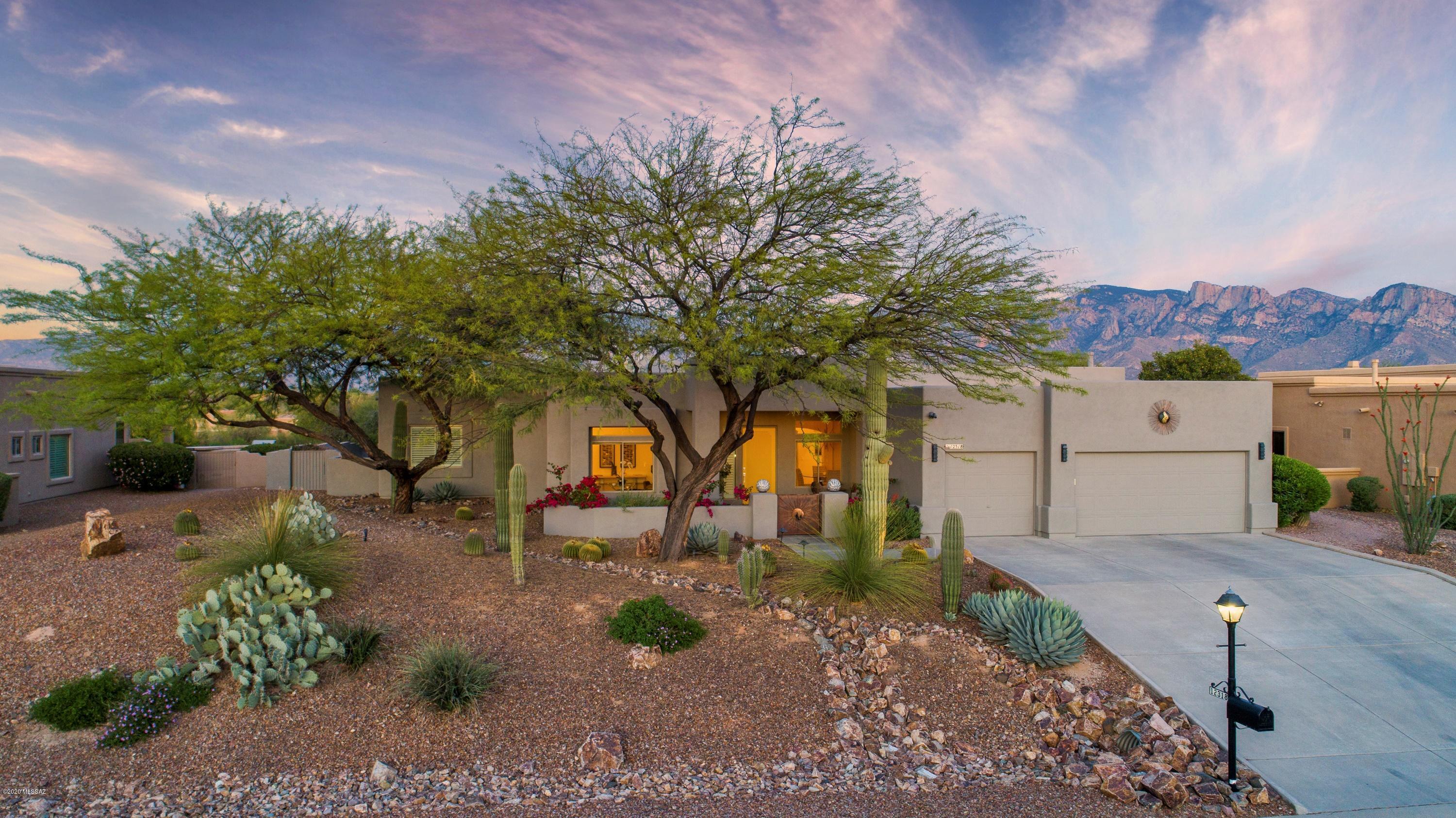 This home is stunning! With beautiful polished porcelain floors, a wall of windows facing the Catalina Mountains and Pusch Ridge, is simply gorgeous. Back yard awaits you, family and friends can swim in the heated pool and cook in the outdoor kitchen, year round.  A new gas cook top in your beautiful indoor kitchen, has plenty of cabinets and center island, for the home chef to enjoy. Split floor plan, with  beautiful views from your master bedroom. Separate vanities and 2 walk in closets in your master bath. Four bedrooms on the opposite side of the house, makes it great for family and guests. Three car garage, with a new mini split, keeps it the temperature you want. Recently painted exterior. This home is well maintained and pristine. It's what living here is all about!