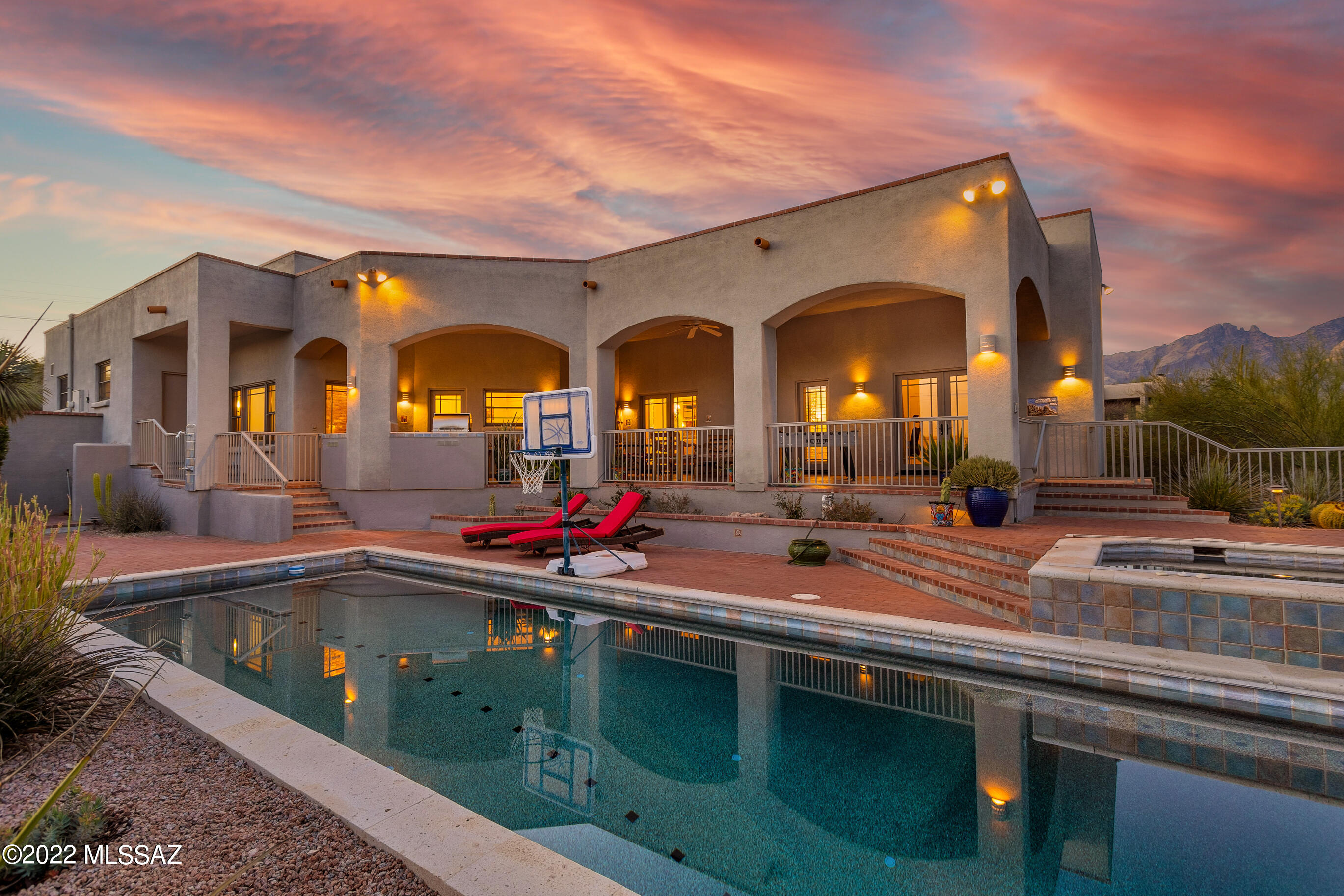 Fabulous custom home built by esteemed Milestone Homes. Gated entry leads down long winding concrete drive to a private sanctuary. Steel framed with stucco finish, courtyard style home with wonderful mountain and city views. Sprawling 2.28 acre private lot bordering riparian area. Four bedroom split floorplan, plus den, three and a half bathrooms. Large kitchen with white and glass cabinets, double Viking ovens and five burner cook-top, Bosch dishwasher, granite counter tops, double sink with walk-in pantry. Formal dining room with built-in cabinets. Large, private master bedroom suite boasts open beamed ceilings, cozy modified beehive fireplace, master bath with soaking tub and shower. Large walk-in closet with built-in cabinetry. Large, deep, bricked covered patio with city views overlooking large pool and spa with custom painted mosaic tile accents. Wonderful built-in grill with side burner. Outdoor shower. Screened garden area outside walled yard.