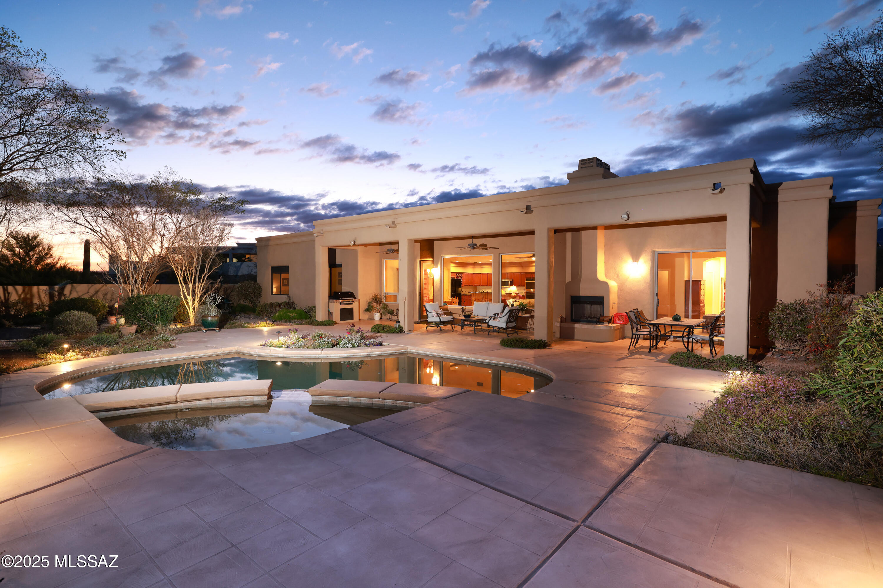 This spectacular home features a tranquil environment, perched on a high ridge with panoramic views of the Tanque Verde valley's wide open spaces. Privacy is enhanced by its location on 1.7 acres at the end of a cul-de-sac within a gated community. A formal foyer greets visitors, who are drawn into the warm and welcoming great room with soaring ceilings and walls of windows overlooking the Rincon Mountains. The primary suite is a luxurious escape from the worries of the day. The spacious walled yard features a sparkling pool and spa, bbq area, manicured landscaping, and gorgeous mountain views.