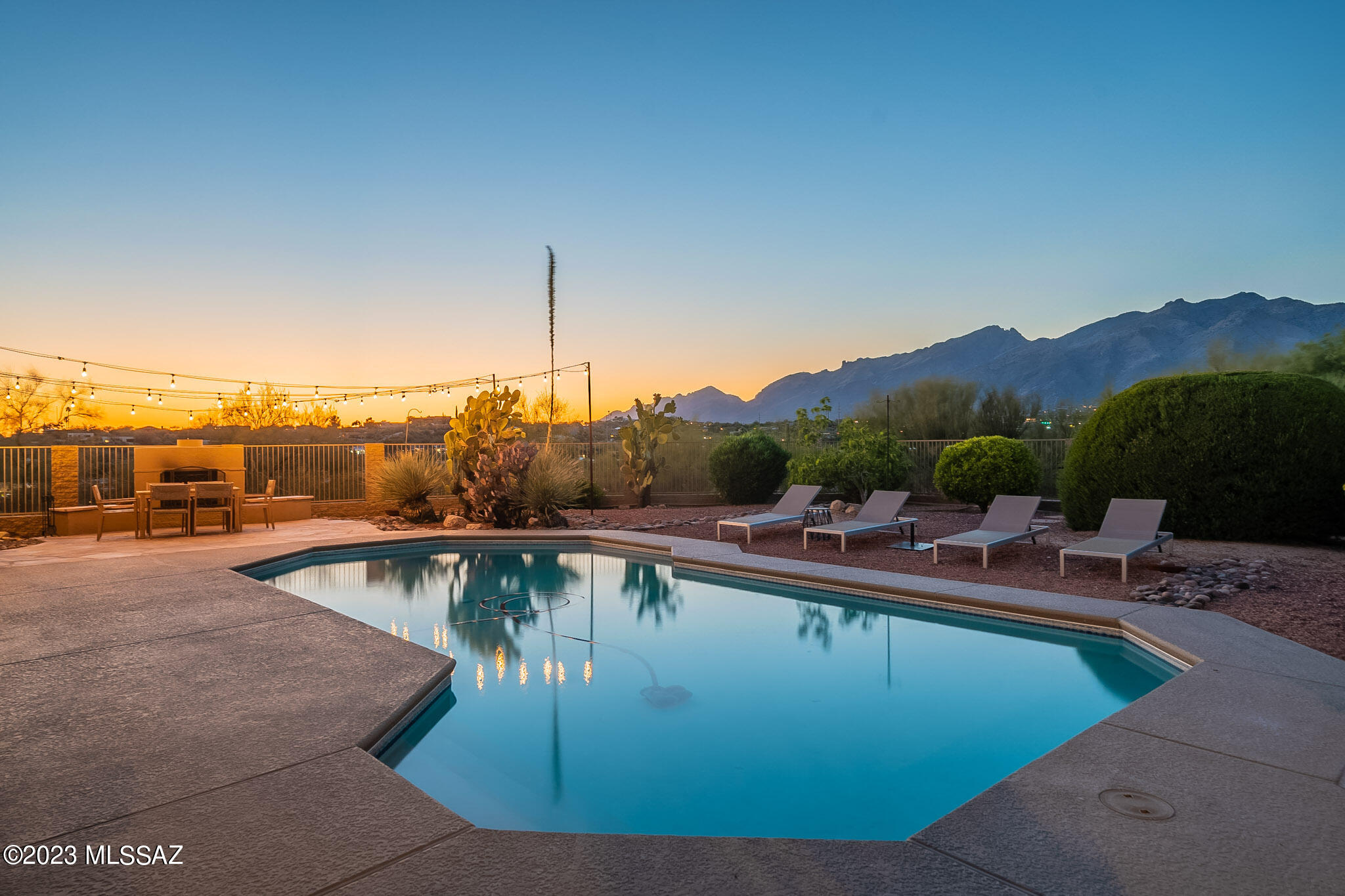 Discover this exquisite ridge-top home with breathtaking views accessed via a serene private gravel drive. Set on over an acre, it offers unobstructed vistas of the Catalina Mountains, phenomenal sunsets, and striking sunrises. Remodeled with an open floor plan, high ceilings, and scored concrete floors. The gourmet island kitchen with a full butler's pantry is the focal point of this inviting space prepared for your culinary adventures or entertaining endeavors. Indulge in the heated pool, hot tub, covered porch, outdoor kitchen, and poolside fireplace for a warm and captivating outdoor experience. The open den allows privacy without seperation and the murphy bed in the guest room is ideal for a flexible space.  Embrace nature's beauty in this idyllic Catalina Foothills sanctuary. Seller is a licensed Realtor in WA