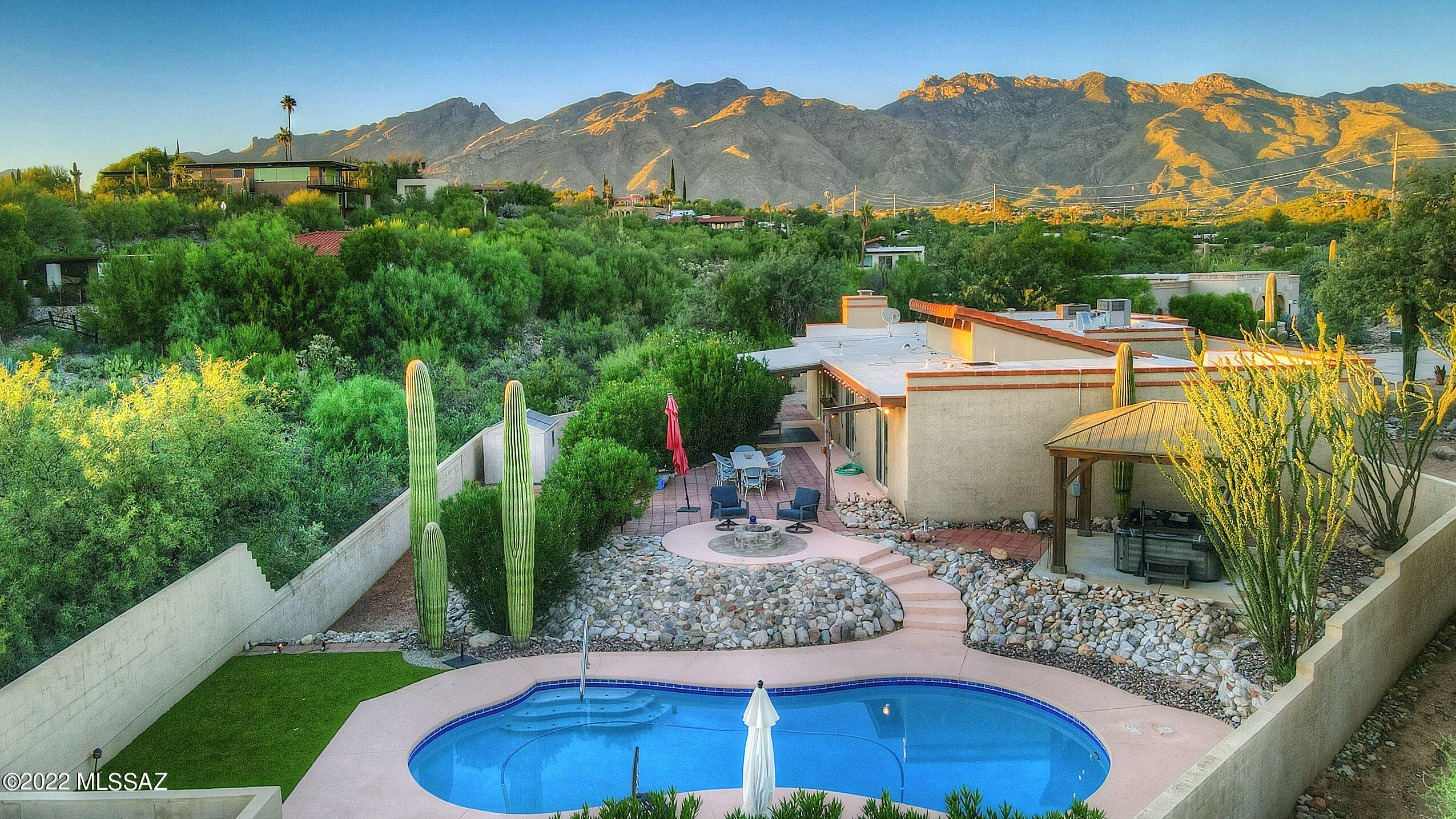 The perfect balance of luxurious foothills living and southwest charm! Nestled on a private cul-de-sac lot surrounded by natural desert, which include over a dozen mature saguaros, city lights and mountain views, this beautifully updated home showcases thoughtful design and generous living spaces. Scored concrete floors and handsome wood beams highlight the main living spaces, and large windows flood the home with natural light. An expansive owner's suite offers private backyard entry, lavish ensuite featuring custom vanity, walk-in shower with double showerheads, and a deluxe walk-in closet. The well-appointed kitchen, bonus entertainment room, and second master suite are all sure to impress. Relax poolside, enjoying exceptional year-round outdoor living in your backyard retreat!
