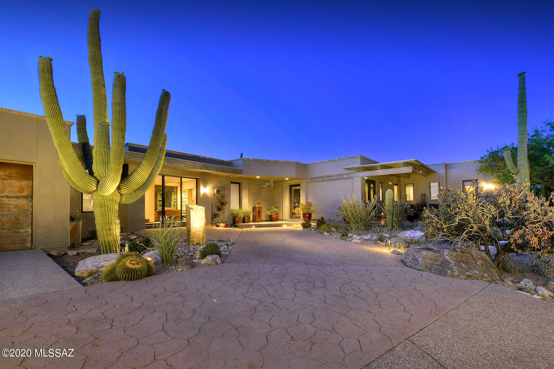 If you love nature, hiking, biking, entertaining, gardening, a quiet getaway in a gated community, this home is for you. Gorgeous Catalina Mtn views, 5 patios, specimen cactus gardens, multiple fireplaces & water features are ideal for intimate & large scale entertaining. The floor plan has split master bedroom suites and an office/guest room ideal for working from home as well as overnight guests. Both master bedrooms are spacious with sitting areas, one with 2 oversized walk-in closets; the other with beehive fireplace and soaking tub.  Open to Great Room, kitchen has extra height counters. All interior rooms have direct access to 1 or 2 outdoor patios and extra height ceilings. There are many artists details, attention to storage is evident thru out w/oversized garage & storage room.
