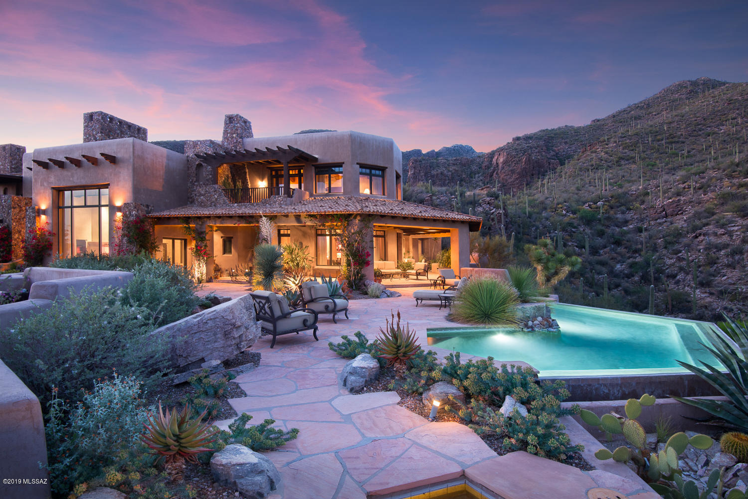Villa Esperero, the privately gated, luxurious, custom-built home in exclusive Rattlesnake Canyon Estates is a property unlike any other w/ exceptional city, mtn & valley views. Impeccably designed by architect Ron Robinette to synthesize
international influences w/ the natural beauty of Tucson, Villa Esperero is a work of art. The 9000 sq. ft. main house sits on 49 acres & is
perched between two magnificent canyons w/seasonal springs & natural pools. Precise detailing & meticulous craftsmanship carefully executed w/ an array of fine finishes including mesquite floors, natural stone & marble. Dramatic great room w/ 25 ft. ceiling, a grand FP & wall of windows overlooking the valley/mtn ranges. Minutes from Canyon Ranch, world class resorts/golf & restaurants/shopping. 5 en-suite bedrooms, 2 of which are master suites. Rattlesnake and Esperero Suites are dual masters.  Sunset, Canyon and Creekside Suites are guest suites. Multiple patios, terraces and balconies overlooking the valley and mountain ranges.  Gourmet kitchen, well equip, butlers pantry and formal dining rm that flows outside for large scale entertaining. Enjoy breathtaking views from every room.  Backyard includes wrap around covered patio w/outdoor kitchen, dining, beehive FP, and infinity edge pool and spa with spectacular views of the city & mountains.  Live in complete privacy.