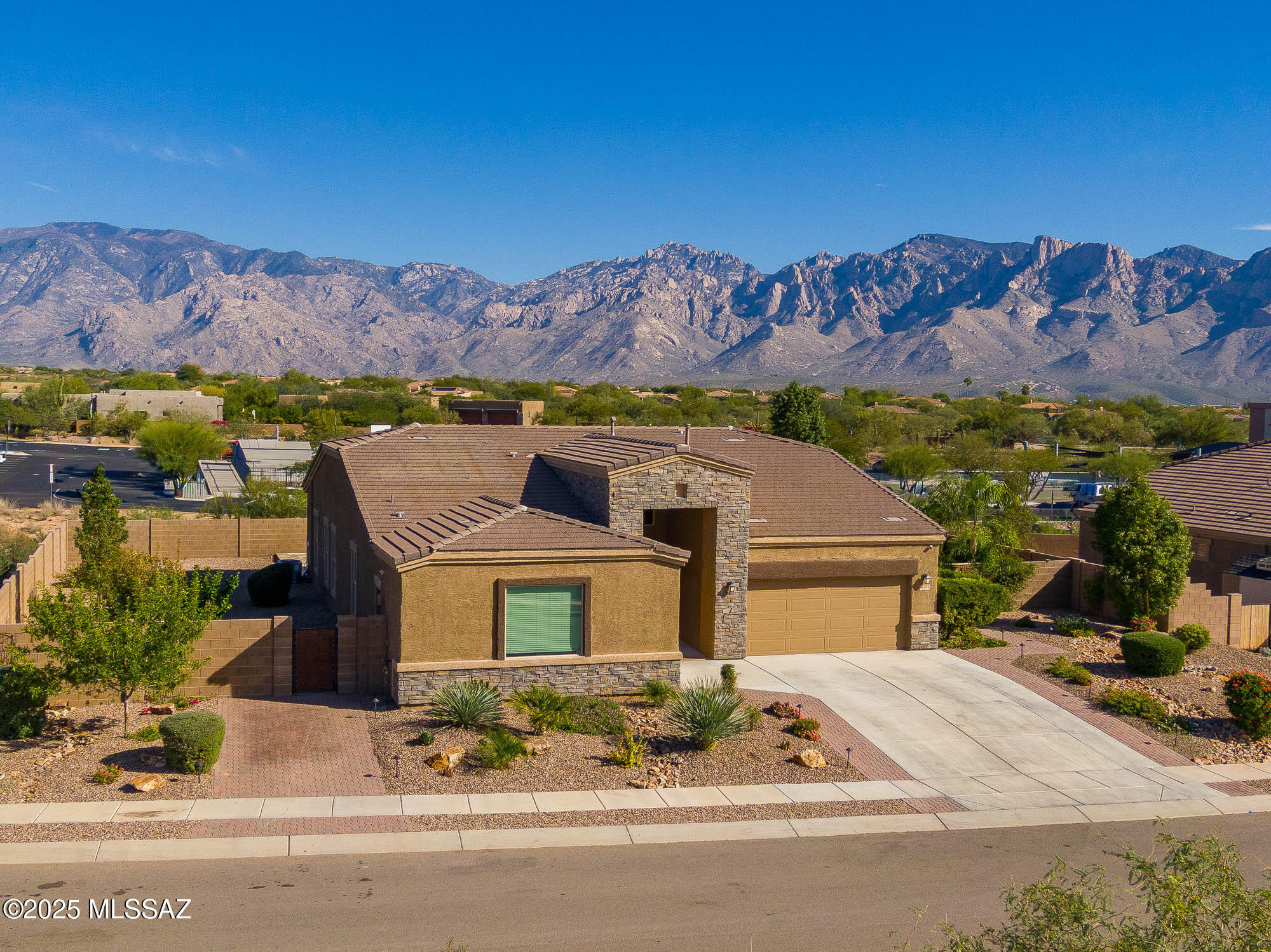Gorgeous D.R. Horton former model home w/ breathtaking views of Pusch Ridge! Beautifully designed 2,534 sq.ft home offers 4 BR 3 BA & flex room on a spacious .295 acre lot. A light-filled foyer opens to a spacious greatroom which flows to a covered patio w/double sliders. Enjoy 10 ft ceilings, custom paint & designer window coverings. The chef's kitchen features an oversized center island, gas cooktop, convection oven, farmhouse sink, granite c'tops,42'' cabinets, pendant lighting & walk-in pantry. The spacious primary suite boasts double-door entry, luxurious bath w/oversized shower & garden tub w/fabulous views.Rolling shutters in primary bath, dining area & patio. The resort-style backyard includes a heated pool w/water feature, lagoon, 3 swim-outs, outdoor kitchen w/BBQ. Spa. 4 umbrella inserts for pool. Artificial turf. Citrus trees. Front & back on irrigation w/timer. 3 car split epoxy garage floors. Walkway lighting front & back. Additional pavers on front north side w/lighting for extra car parking. The latest in home technology and automation. The views and location are stunning. In the heart of Oro Valley close to all amenities.