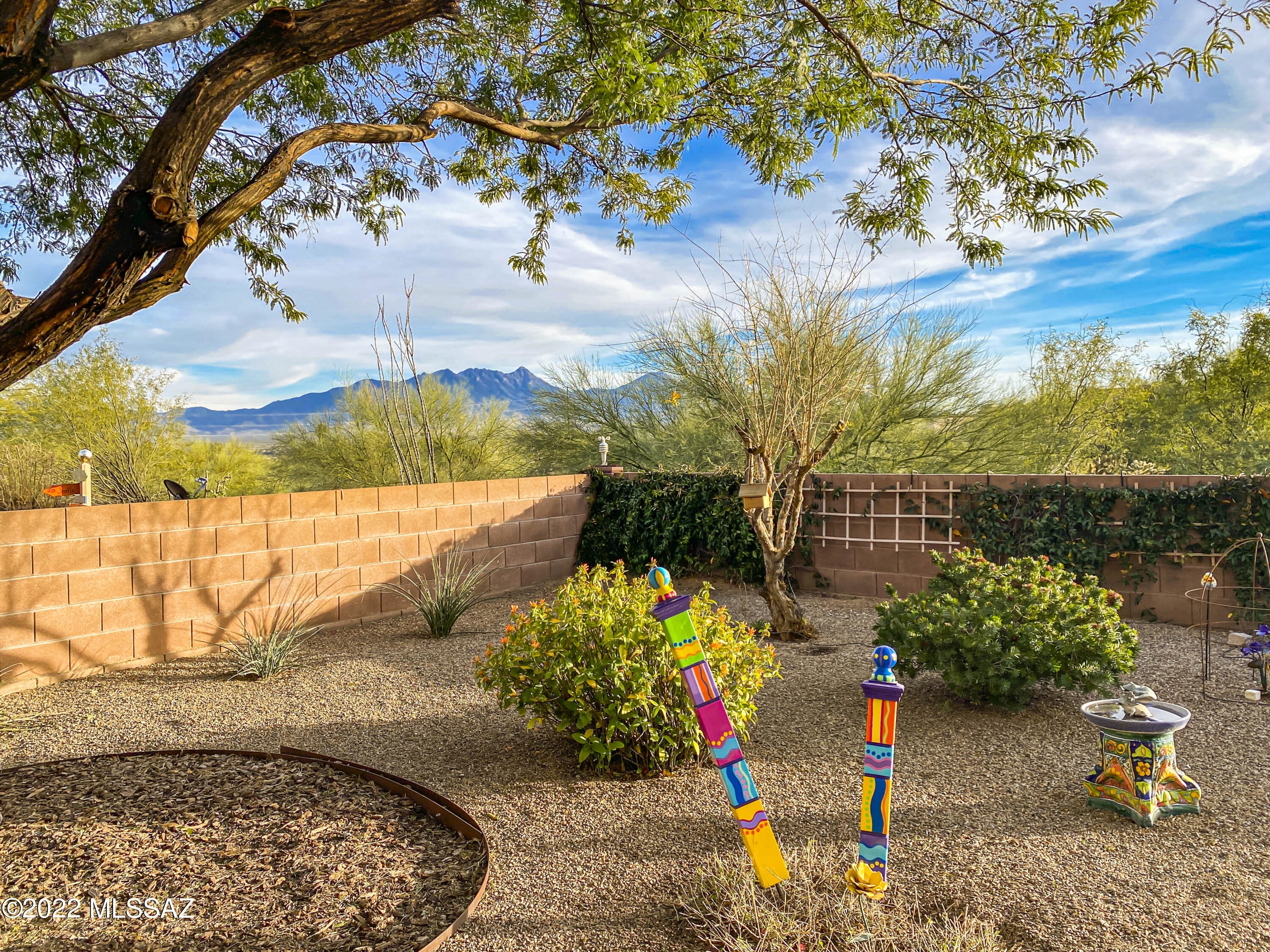 Centrally located and in a quiet neighborhood, this house is situated on a premium lot with views of natural desert behind the home.  Step inside to find a great room floorplan with distinctive wood plank tile flooring with a wall of windows bringing the desert views right inside.  The kitchen island provides a walk-up bar with a prep-cook's dual sink and stainless appliances.  In the owner's suite you'll find delightful bay-window views and a spacious bath with separate his and her vanities along with a built-in makeup station.  You'll love the expanded space of the hobby and laundry room with its indispensable utility sink.  Enjoy open-air living and dining in your fully screened patio where you can relax free from the elements while appreciating the natural environment, desert landscape and beautiful views of the Santa Rita Mountains!