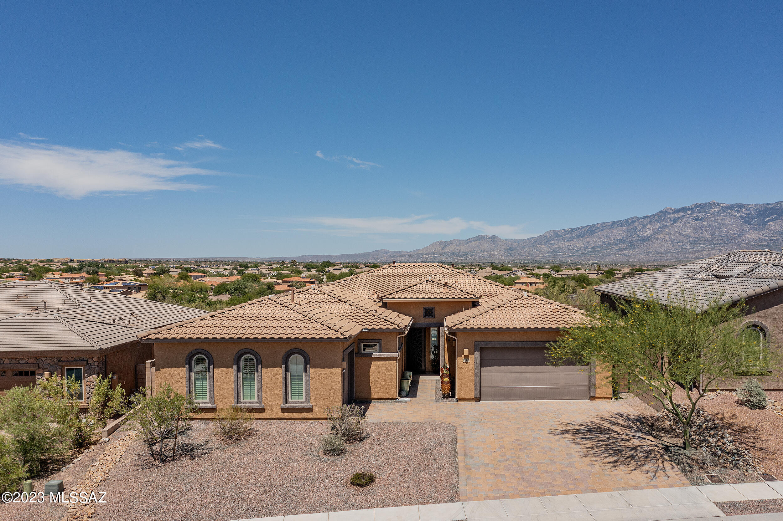 Beautiful Next-Gen home located in the heart of Rancho Vistoso. This 5 BR, 3.5 BA dramatically designed home with 10 ft ceilings, open floor plan, plenty of windows with plantation shutters, and fantastic views of the Santa Catalina Mountains. Includes Gourmet Kitchen with upgraded Monogram appliances. Separate 1 BR guest quarters with private entry from the front courtyard. It has a kitchen with 42'' cabinets, granite countertops, a large living area and breakfast nook, a stackable washer/dryer, a bathroom with a walk-in shower, and a separate entrance to one car garage. Climb up the spiral staircase to the patio deck and enjoy the magnificent mountain views of the Catalinas, Tortolita Mountains, and Oro Valley. You'll love the Heated pool surrounded by travertine tile.
