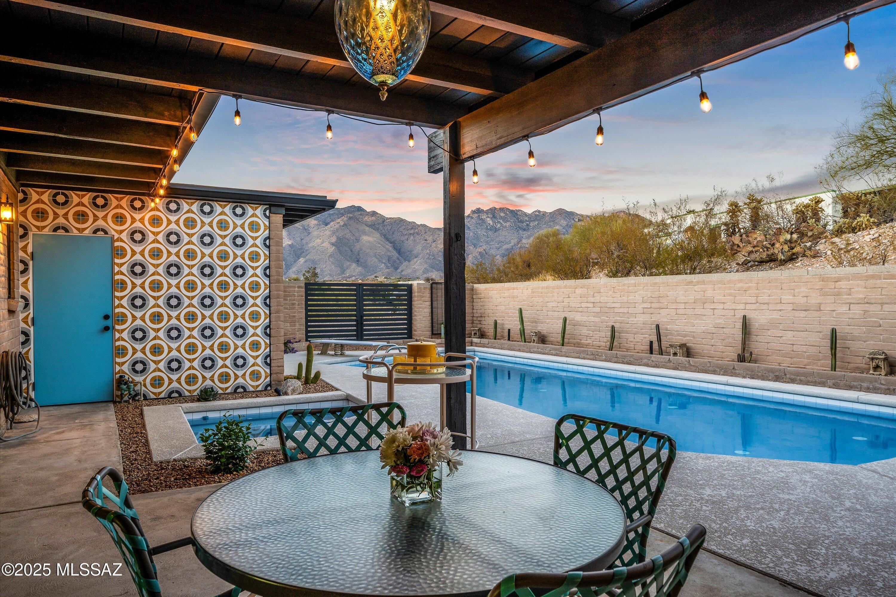 Tucson Association of Realtors Home Tour Winner! Located within the Catalina Foothills, this impeccably renovated midcentury modern home offers a perfect balance of timeless design and contemporary upgrades. Perched upon an elevated parcel this property has sweeping views of the Santa Catalina Mountains by day and twinkling city lights by night. 

Stepping inside you'll find architectural details such as the polished concrete and terrazzo tile floors, wood-beamed ceilings, a cozy gas fireplace, and striking breezeblock. The family room opens to the backyard pool and patio area through 16-foot panoramic glass doors, filling the interior with natural light and offers a seamless indoor-outdoor connection. 

The designer kitchen is dreamy, featuring sleek vertical grain slab cabinetry, quartz countertops, glass-fronted appliances, and an under-counter beverage refrigerator. 

Bathrooms echo this modern aesthetic with matching cabinetry and countertops, while the primary suite offers a tranquil retreat that includes ample storage, dual sinks, and an oversized shower. 

While the interior is stunning, this home was designed to appreciate the outdoors with three of the four bedrooms opening to a patio. Outside, the resort-style backyard includes a resurfaced pool and spa with all new equipment, an extended covered patio, and a new drip irrigation system. 

Additional upgrades include new dual-pane windows, a new concrete driveway, a new 200-amp electrical panel with surge protection, and a two-car garage with additional cabinetry. 

Perfectly suited for those who value both design and functionality, this home offers a rare blend of midcentury modern refinement and modern comforts in one of Tucson's most desirable neighborhoods. Embrace the lifestyle you deserve in this remarkable Catalina Foothills retreat.