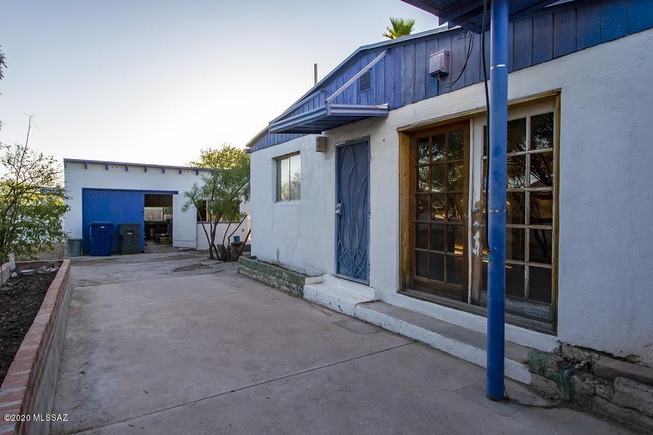 Strictly as-is, cash buyers only.  Looking for a private compound? This rambling home can be refurbished and used in a multitude of ways.  THREE kitchens! Perfect for multigenerational families, artists who want live/work/share space, and it sits on a DOUBLE R-2 lot!  .32 of an acre, all fenced, and with gorgeous mesquites, room to garden, set up your kiln,  and truly, a dog's paradise.  Home needs work, though electrical and some plumbing have been worked on. Needs cooling.  Garage makes a great studio/workshop, and there's a gated parking area that would be perfect for another garage or carport.  Build additional units, or plant your urban farm on the extra lot.  This is a vintage gem, close to lots of shopping, UA.  AS-IS.  Sellers will do no repairs.