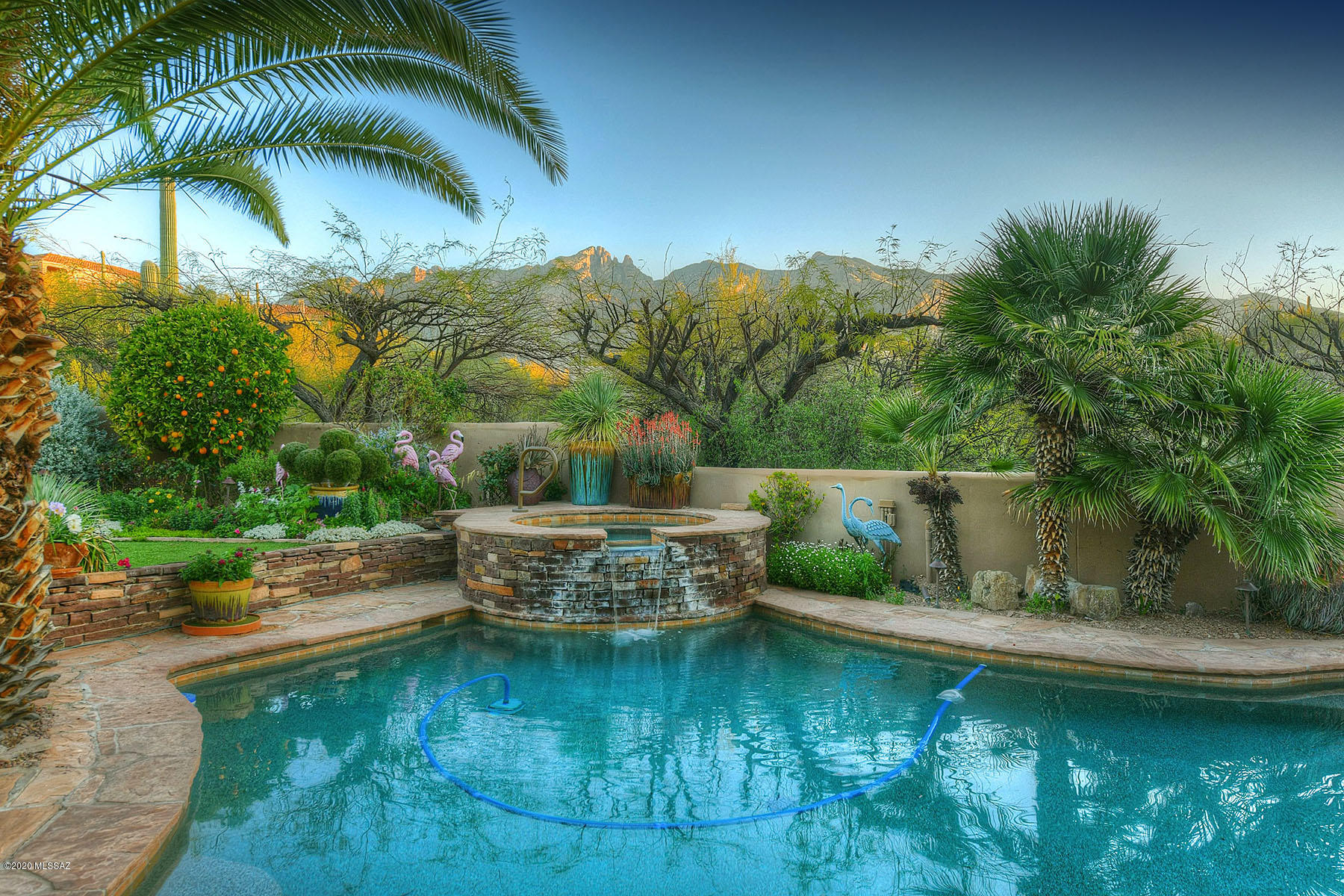 Contemporary Southwestern gem with beautiful, recently updated kitchen featuring huge windows to take in the Catalina Mountain views, ss appliances, custom cabinets, wonderful center island that doubles as a breakfast bar AND an eat-in charming breakfast nook, all open to a viga-beamed great room with cozy fireplace & glass doors that lead to the outdoor entertaining area complete with deep & cool shaded porch, built in BBQ, sparkling pool & heated spa, turf & lush ez care plantings.  Back inside you'll find refinished saltillo tile throughout, formal living & dinging rooms, large master suite w/remodeled bath that includes luxe soaking tub, guest room split away from the others, heated/cooled garage & quality Pella windows throughout!