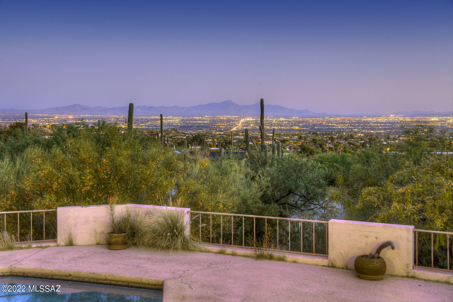 Seller will consider offers between $895,000 and $950,000. This vintage 1976 territorial-style home is nestled at the top of a cul-de-sac, on a high lot in guard-gated Skyline Country Club Estates and offers unobstructed, sweeping 180 degree ''million dollar'' Tucson city views! A blank canvas ready for your designs, remodel and updates. Enter the 2,378 sq. ft. all masonry stucco residence through a welcoming courtyard entry with brick patio and mountain views. The spacious great room/dining area features a cozy corner fireplace, a beamed ceiling, and a wall of glass framing sparkling city lights. The eat-in kitchen provides a breakfast area, ample all-wood cabinetry and a center-island with a butcher block counter top. The primary bedroom offers access to the covered patio, city views, a large walk-in closet, and dual vanities. The den/3rd bedroom features access to the covered patio, city views, and a corner beehive fireplace. Additional features include an oversized laundry room with a desk, wash sink & pantry, and a 2-car garage with storage. Enjoy the back patio offering an expansive back porch, a pool, and panoramic city views! District #16 Schools.