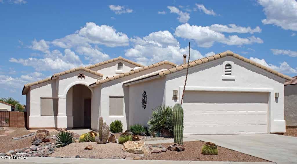 Simply a beauty! Fabulous open floor plan with vaulted ceilings, indirect lighting, & lovely throughout.  Kitchen boasts pantry, gas range with a conventional/convection combo oven, long breakfast bar, top down-bottom up blinds, beautiful wood laminate and tile flooring, rev. osmosis. Inviting fam. room w/ lots of windows to enhance the Santa Rita views. Beautiful ceiling fans and Berber carpet. Mstr bdrm has bay window, ceiling fan & tasteful colors. Mstr bath has dual sinks, exec ht vanities, garden tub w/ sep. lg shower. Large walk-in  closet w/ extra shelves.  Den w/ oak laminate flooring & dbl doors. Huge laundry rm w/sink,  Kenmore washer/dryer & in-wall ironing brd. Ext garage w/storage shelves and water softener. Covered brick patio w/ views & large yard. Home Warranty - Plan C.