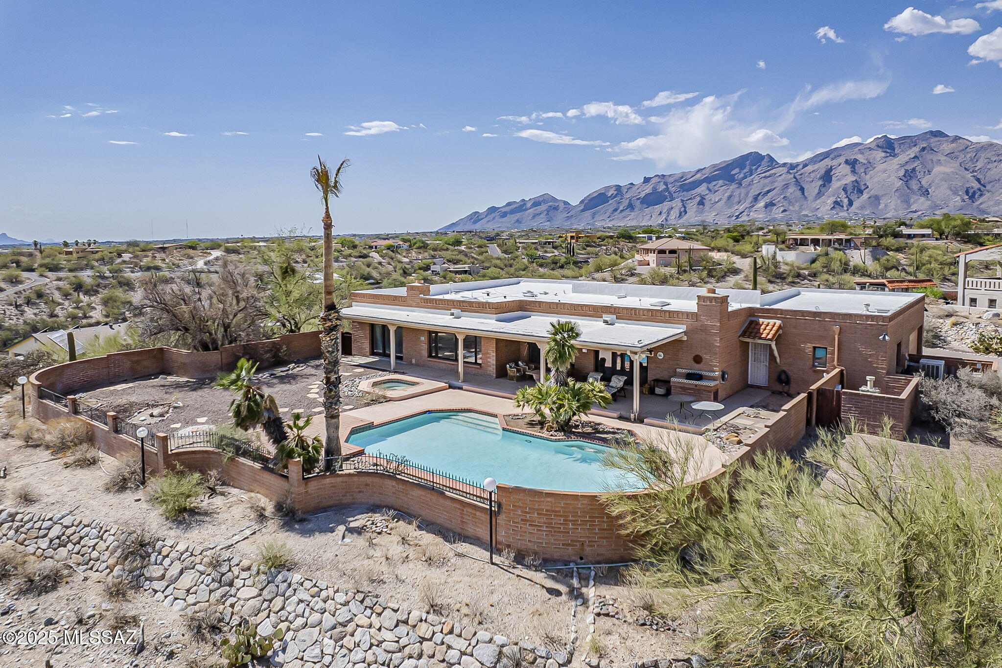 This is a classic Territorial Style Home located at the end of the neighborhood cul-de-sac with Ridge Views of city lights and the impressive Santa Catalina Mountains, featuring custom beam wood ceilings, spacious kitchen, breakfast bar & prep area, expansive cabinet space, time-honored intercom system, Saltillo Tile flooring, Pella Windows and Doors throughout with multiple exits leading to the back patio. The bedrooms and baths are large while offering a split bedroom with 4th guest bed and bath on the opposite area of the house as guest quarters/office or study. Large deep pool and space. Could be a wonderful gathering spot and relaxing area. The adjacent Parcel 109-22-3130,  lot #33, 3970 N Rio Verde Vista Dr , 0.84 ac being sold for $230K with property 5951 E Placita De las Luces.