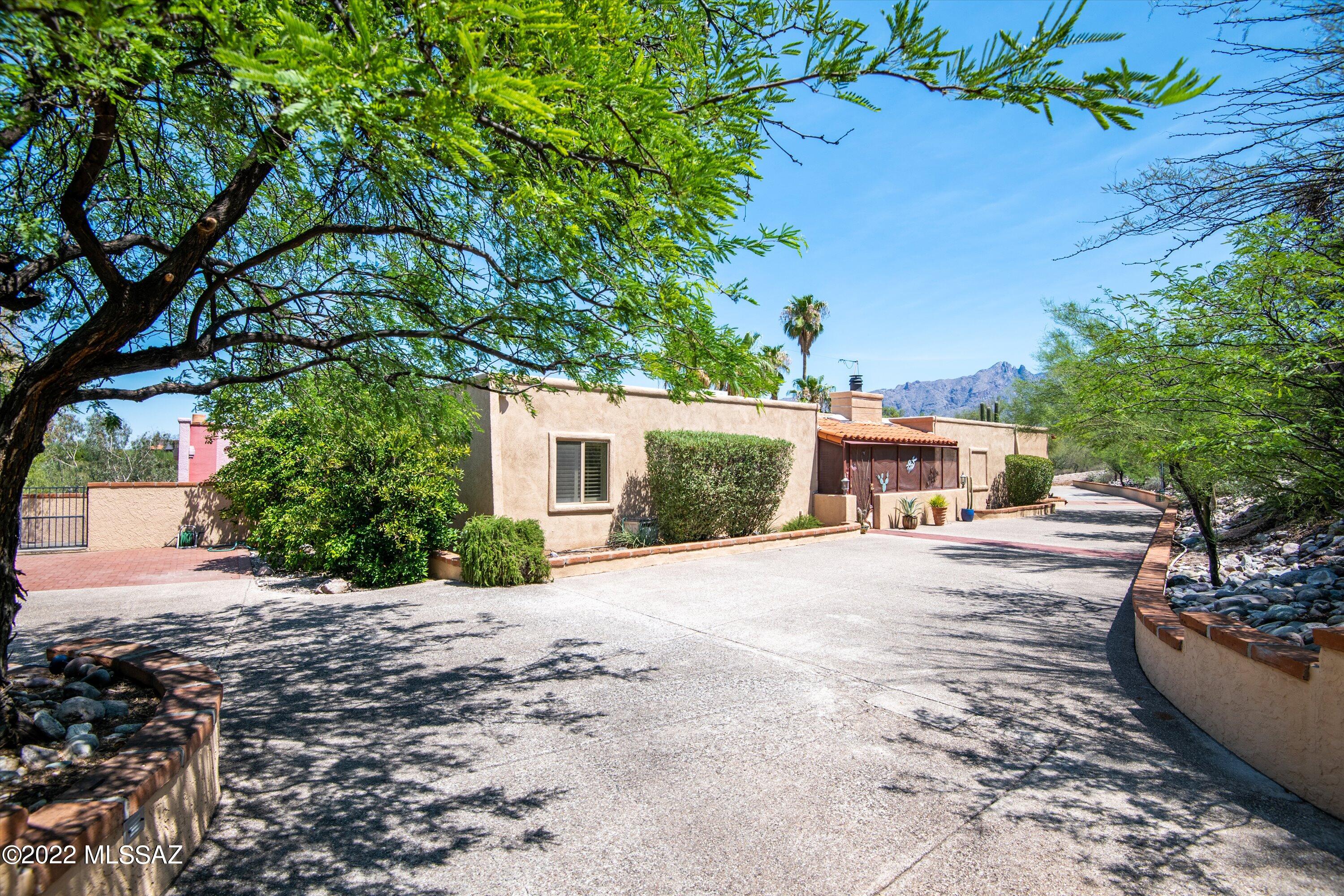 If you love to sit on a deck look stare at the mountains of Tucson then come see this home! This outdoor space is an entertainers dream. Featuring a oversized deck, solar heated pool, Napoleon gas Fire Pit Area, Wood Burning Fireplace, Outdoor Kitchen, large grass area for kids to run and play, mature trees, citrus trees, half court Basketball Area and a rooftop viewing deck. The main single story home is 4 Bedrooms and 3 full Bathrooms with NO INTERIOR STEPS. Split Floorplan, 
Travertine Flooring, Granite Countertops, and Gas Appliances. 2 Gas Fireplaces in Living room and Master Suite. Built in cabinets/desk in one bedroom to be used as an office. The second building is about 400sqft, features, plumbing, 220 electric, mini-split, great space for workshop, office, maybe a guest house?