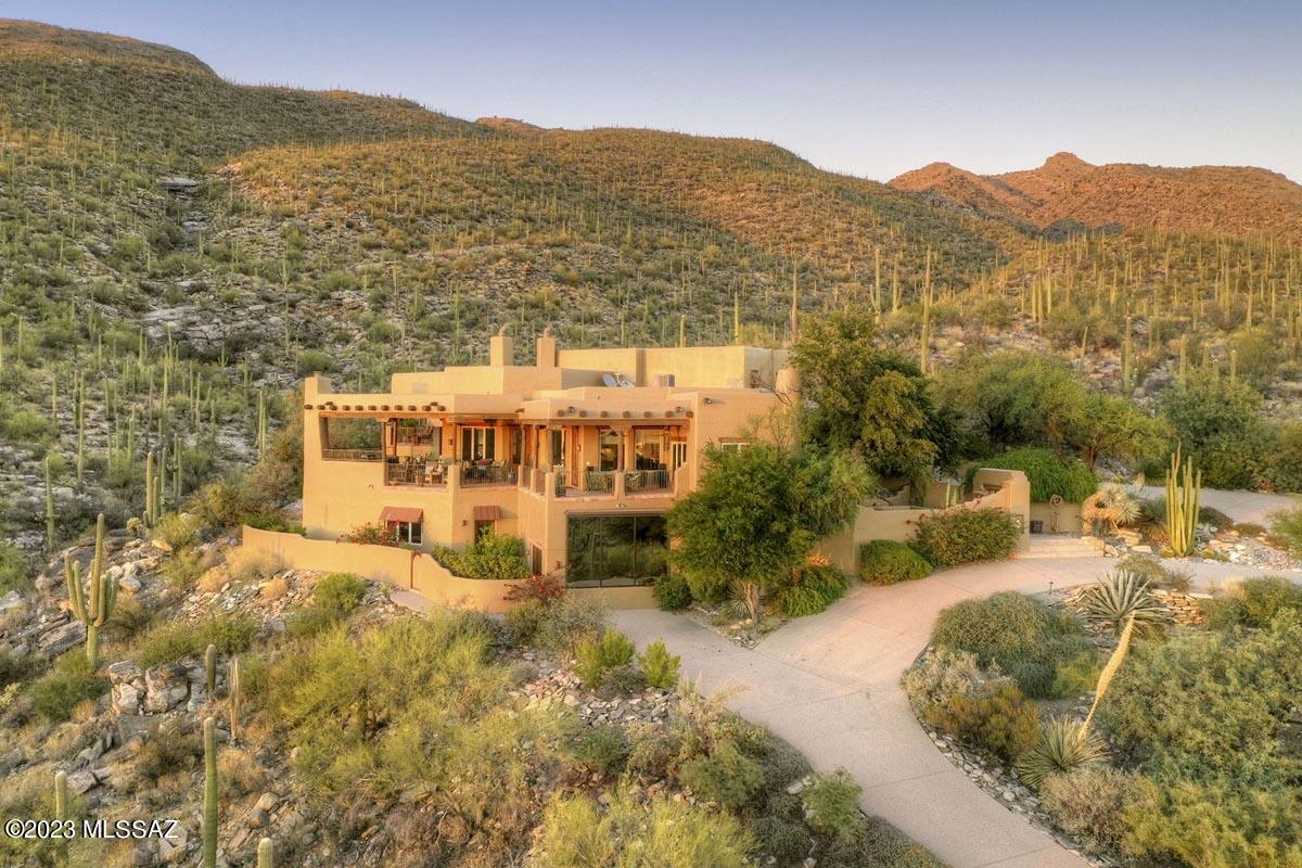 Absolutely breathtaking views of mountain, sunset & city lights await from this Santa Fe home built by renowned builder, Ray Birch, nestled at the base of the national forest on 4 acres. This spectacular home has gorgeous wood-beamed ceilings, Imperial plaster walls, open island kitchen, SS appliances, multiple fireplaces & a spacious, gracious floorplan. Perfect for entertaining! Luxurious primary suite has its own viewing deck. Commune with nature from the very private waterfall, spa & pool, and multiple verandas. Over $250,000 worth of upgrades and renovations (including solar panels) have been invested within the last 5 years to make this elegant home absolutely top notch. Plenty of room for friends & family in the guest casita and game/hobby room. Your own secluded sanctuary awaits!
