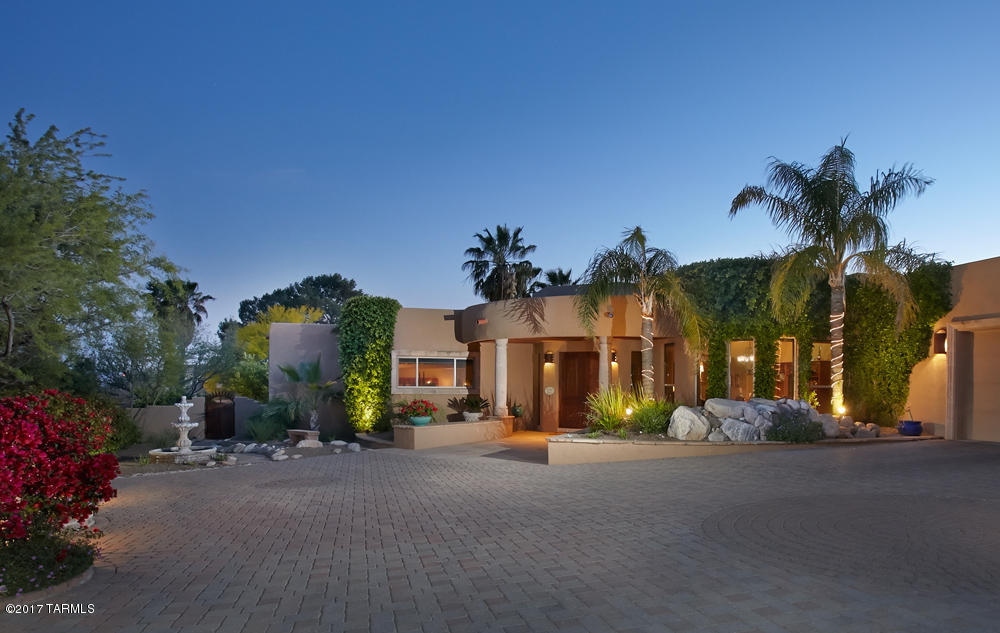 Stunning custom soft SW Contemporary nestled in the Catalina Foothills.   With sweeping views of the Catalinas & city lights, the 3564 sq ft. home boasts a split floor-plan w/4BR, 4 baths, 3 fireplaces & master ste w/sitting area. Gourmet kitchen & 350+ bottle wine cellar! Enjoy outdr living at its best in the 2 cov. patios, pool, spa, BBQ ramada & elevated patio & kiva FP.  A private walled .86 acre enclave w/stone courtyd, Cantera columns, fountain & waterfall, enhanced by new landscaping! Open floor plan w/12' ceilings & Travertine & accented by new Karastan BR carpet. Perfect for casual or more formal entertaining inside & out. 3 car garage w/built in storage & work space. This world-class residence is priced below current appraisal!  Owners are licensed Real Estate agents in Arizona.