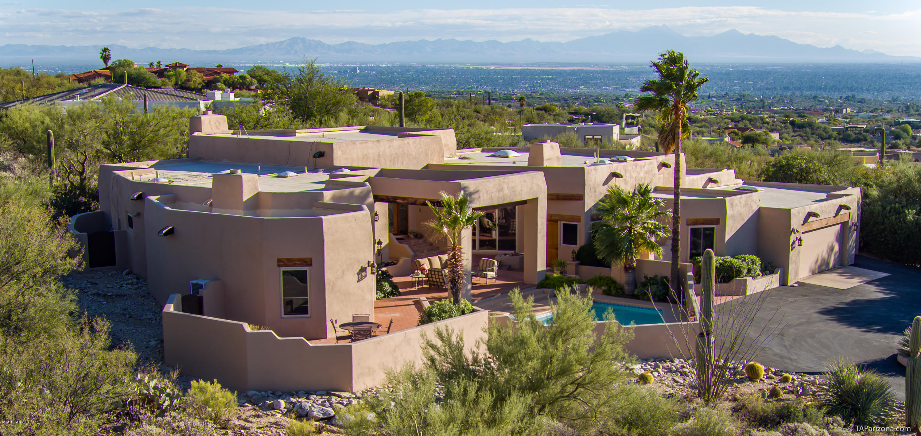 Exquisite ridge top home in the gated neighborhood of Sin Vacas. This 4085 sqft, 1 acre estate has a split bedroom floorplan w/ 4BR/3BA/3car and pool/Spa. Enjoy the breathtaking views out of the picturesque windows of mountains, sunsets and/or city. The meticulously maintained home is complimented with newer doors, carpet, windows, skylights, water heaters, A/C's and kitchen and baths. The master bedroom will be sure to delight the most discerning buyer with His and Hers walk-in closets, attached exercise room, fireplace and spacious sitting area. Common spaces include a large formal dining room and beamed ceilings and fireplaces in both the living room and family room. Location is superb being just minutes from the Fashionable La Encantada shopping district.