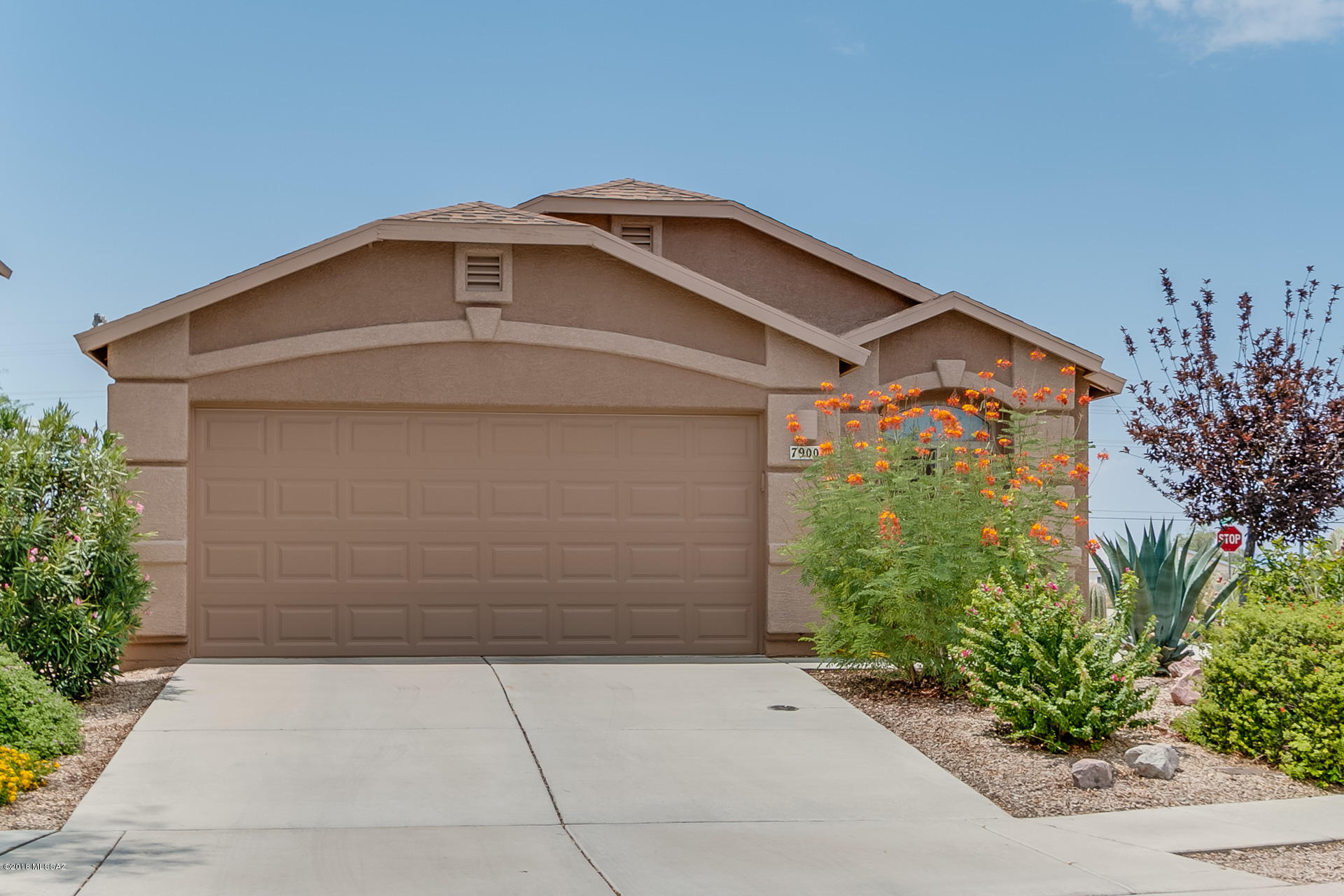 Pride of ownership in this single-level, split three bedroom floorplan with two baths.  This home sits on a corner lot and is 1556 square feet.  The kitchen has oak cabinets, black appliances and an eat in dining area.  The home has a security door,  ceiling fans throughout, some wood blinds, tile, laminate, and carpet flooring in the bedrooms, new garage door, home was painted interior and exterior, and a/c serviced yearly Landscaped front and back yards and were decorated with decorative rocks.  This home has been lovingly cared for.