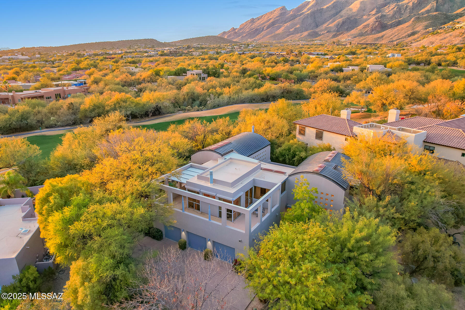 This extraordinary home, inspired by the iconic designs of Louis Kahn and reminiscent of the Kimbell Museum, is a modern architectural gem nestled in the prestigious Ventana Canyon Estates. Spanning 4,556 square feet, this 4-bedroom, 4-bathroom residence seamlessly blends bold contemporary design with the serenity of desert living. The distinctive barrel-shaped metal roofs and central courtyard create a striking aesthetic while fostering natural light and a harmonious indoor-outdoor connection.

The home boasts two primary suites, including one conveniently located on the main level, offering flexible living arrangements and private luxury. The upstairs primary suite features a sunken tub, a cozy fireplace, and a wrap-around deck showcasing breathtaking city and mountain views. Vaulted ceilings throughout the home enhance the sense of space, while a loft overlooking the living room adds an open, airy feel. The living room, with its fireplace and expansive windows, creates a warm and inviting atmosphere.

At the heart of the home, the kitchen is both functional and elegant, featuring sleek black granite countertops and modern cabinetry. A unique open wall looks out onto the central courtyard, creating a seamless connection to the outdoors. For added flexibility when entertaining, sliding panels allow the kitchen to be closed off, offering privacy and a refined touch. Art enthusiasts will appreciate the abundance of wall space, perfect for displaying a curated collection.

This architectural treasure combines bold design, thoughtful details, and a prime location in Ventana Canyon Estates, offering an exceptional living experience in the heart of the desert.