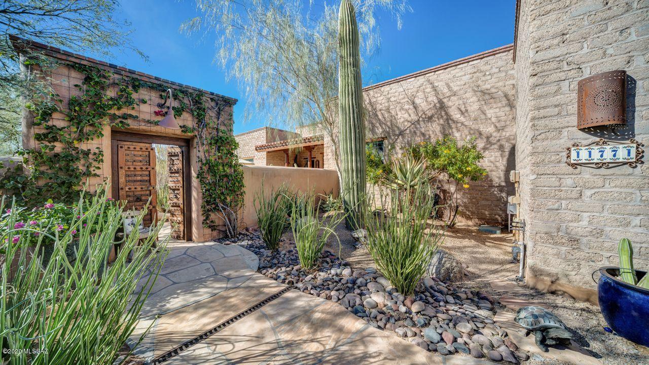 Authentic Stellar-Gray adobe home in gated Sky Ranch! Surrounded by 100's of acres of protected natural open space. Antique doors open to walled CTYD w/ beehive FP & lovely plantings. Iron & glass front door opens to great room w/ FP, beamed wood plank ceilings, wall of windows to the patio. Graceful columns lead you to formal dining. Kitchen features, knotty alder cabinetry, Viking gas range, wine fridge, mesquite wood island counter w/seating. Laundry & butler's pantry nearby. Secluded master w/ FP, walk in closet. Archway leads to BRs 2 & 3 plus hall bath. Large covered patio for dining w/ blt in BBQ, raised pool & spa, viewing Tortolita Mtns & desert. Separate CASITA has seating & sleeping area, bar sink w/ fridge. FRPL to stay cozy. Quality finishings thru-out. Magical desert oasis