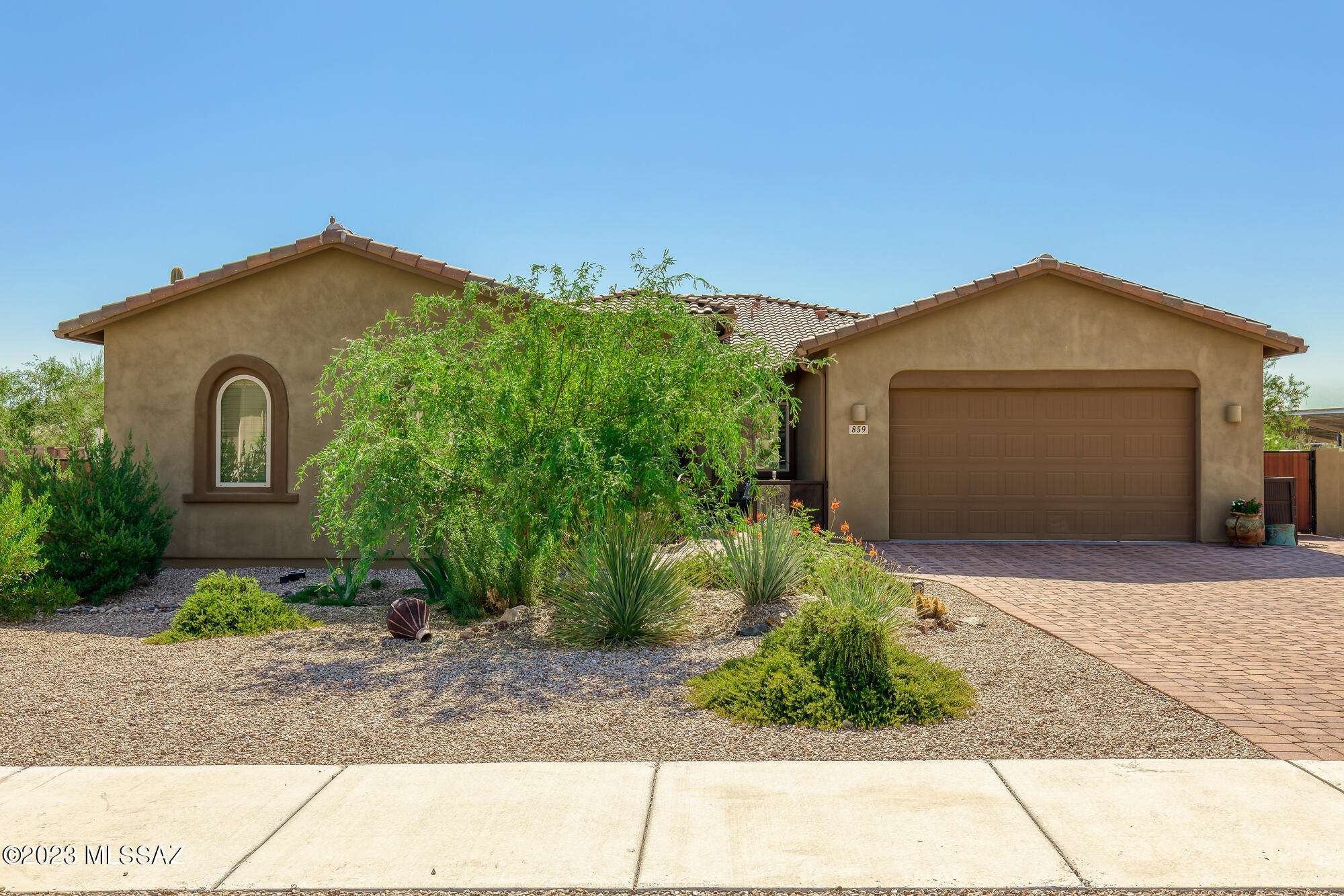 This delightful home nestled in a peaceful and friendly neighborhood is the perfect blend of comfort, style, and functionality. 
As you approach the property, you'll be greeted by a beautifully landscaped front yard, complete with lush greenery and vibrant desert flowers. Step through the charming iron gate and enter into the courtyard. From the moment you enter through the front door, you will be captivated by its warm and inviting ambiance. The architecture of the home is clean and contemporary. The large great room sliding doors invite you to relax and enjoy the tranquility of the desert surroundings while gazing out at the pool and lush desert surrounds. The interior of the home boasts a bright airy open-concept of living space. Owned solar is a big bonus!! The interior of the home boasts a bright airy open-concept. A split floor plan with 4bd 3 ba and a flex room are sure to meet you're needs for space, storage and privacy. Wood look tile flooring throughout, quartz countertops, designer lighting and ceiling fans. The heart of the home, the kitchen, is a chef's dream come true. It boasts modern stainless-steel appliances, ample counter space for meal preparation, and a convenient center island, perfect for enjoying quick breakfasts or hosting cooking parties. The adjacent dining area provides a lovely spot to savor meals with loved ones, with a view of the backyard through the large windows and sliding glass doors. This home also features a Passive water collection system throughout the yard.  Come and experience the comfort and joy this home has to offer. Schedule a visit today and start envisioning your future in this spectacular property.