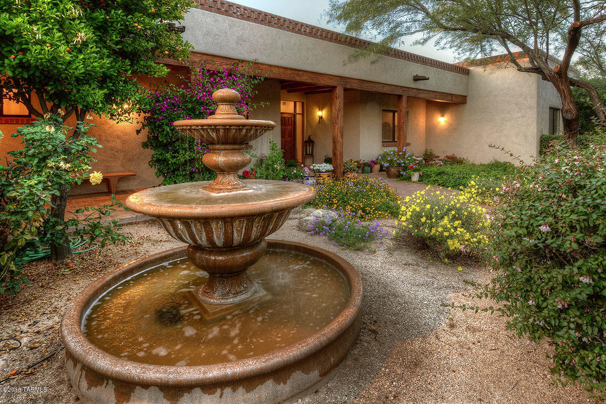 Outstanding Spanish Colonial five bedroom home by architect Bill Condit, architect for Butler Santa Fe style homes, on a stunning private 3.32 acre view lot in Tanque Verde Valley. Courtyard entry with fountain leads to handcrafted mesquite front door into foyer and great room with high beamed  and planked ceiling, Saltillo tile floors, numerous built-ins, walls of windows, all masonry fireplace and unobstructed Catalina Mountain views. Gourmet kitchen offers oversized center island, breakfast nook and adjacent, cozy family/television room. Gracious master suite features mountain views, all masonry fireplace and master bath with dual vanities and spa tub. Expansive three car garage with storage and work area, professionally landscaped rear yard.