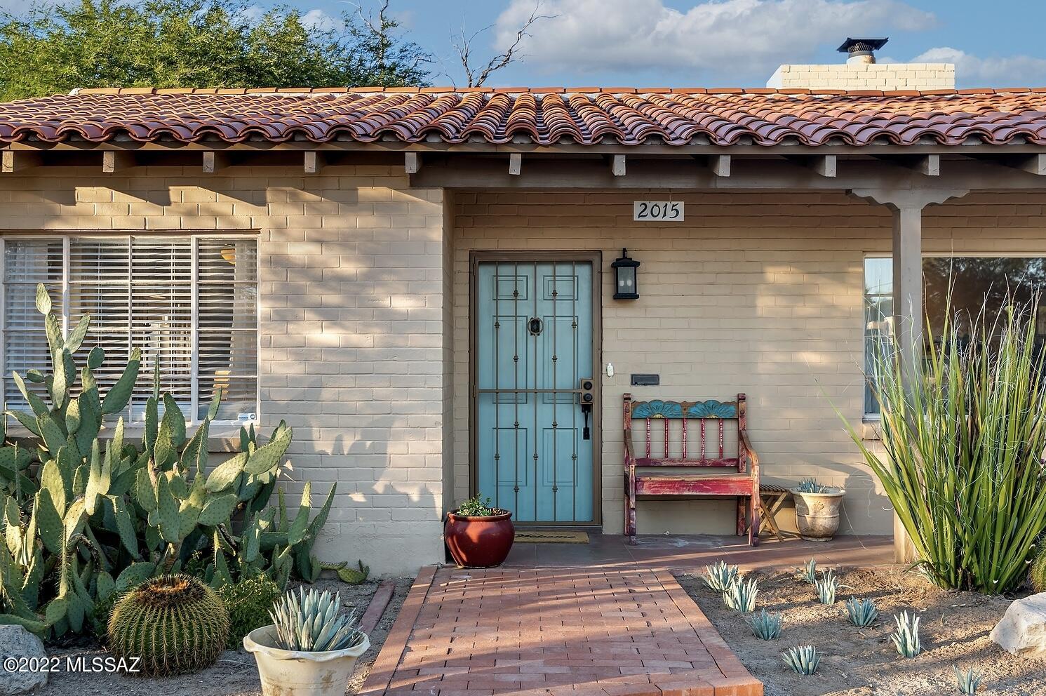 Just Steps from the acclaimed Arizona Inn and Banner Hospital, this updated brick home is situated on almost a half acre lot in Historic Catalina Vista. The gracious living room has a wood burning fireplace, wall of built-in bookcases, and teeming with natural light. Enter the kitchen through a vintage butler's door and enjoy the updated cabinetry, abundant storage, and contrasting island. The Adjacent dining room offers views of the den and stunning backyard. Lush landscaping, Views of the mountains from the spacious porch, and a large brick patio make this a year round delight. Inside the primary suite offers a classic corner window, large walk-in closet, and bathroom with dual sinks and separate soaking tub. This elegant home also has two additional bedrooms and two additional bathrooms, plus a laundry/mud room. Owned solar system, historic tax status, copious off street parking, and detached workshop make this house an exceptional opportunity in one of Tucson's most desirable locations.