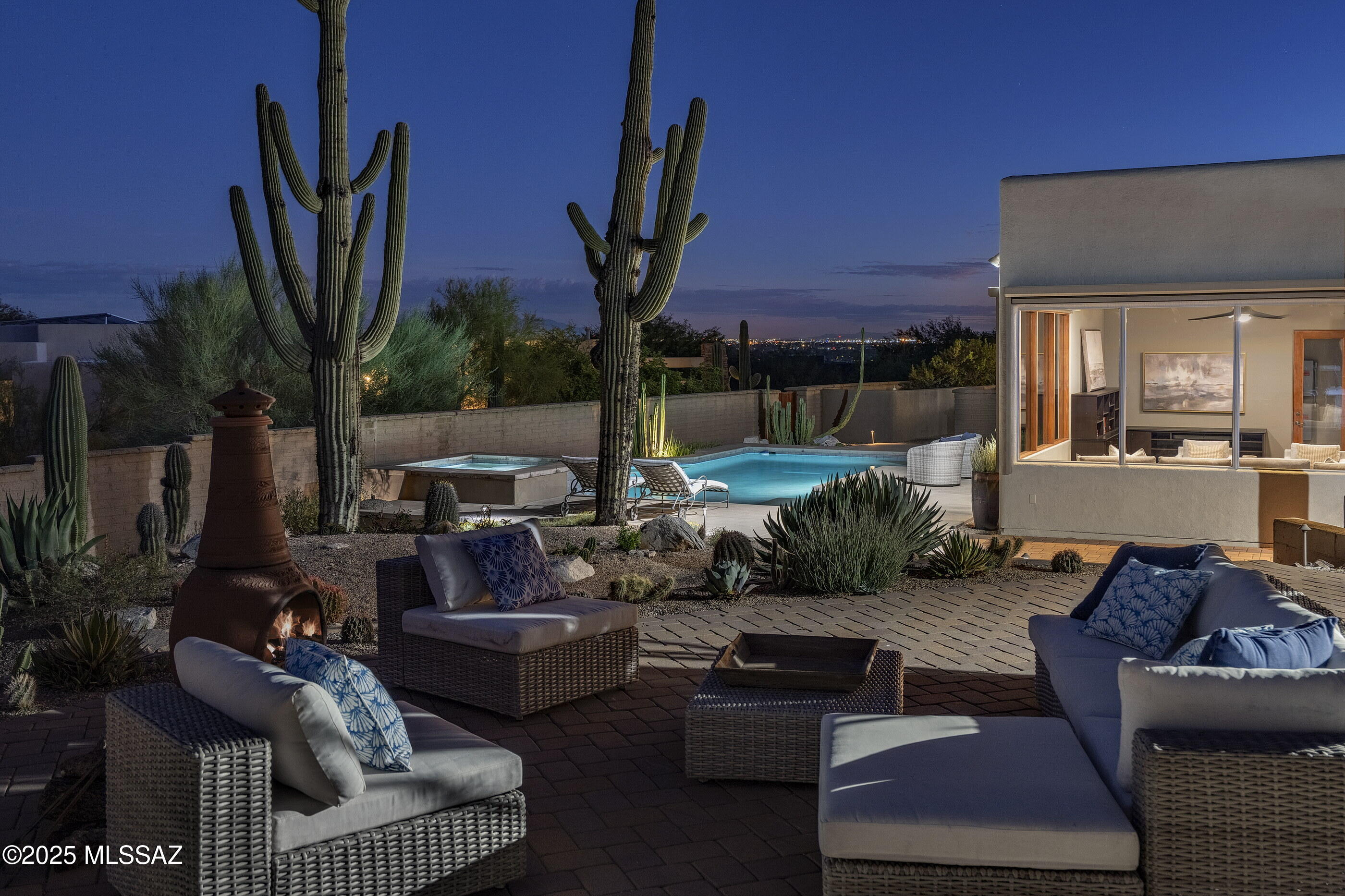 Perched gracefully atop an elevated homesite, this exceptional residence offers sweeping, unobstructed views of the Catalina Mountains, thoughtfully framed by artfully curated desert landscaping. Rooted in the architectural heritage of the region yet infused with contemporary refinement, the home strikes a harmonious balance between timeless elegance and modern sophistication. A gently winding drive introduces a formal motor court, guiding you to an enchanting entry courtyard that sets the tone for the home's classic central courtyard layout. Nearly every principal room opens to the outdoors through deep, shaded portals, arcades, and terraces, creating a seamless connection between interior and exterior living. Spanning 4,086 square feet including 3,650 square feet in the main residence and a 436 square foot detached guest casita, this home exemplifies enduring craftsmanship and carefully selected materials. The landscaping is a celebration of the Sonoran Desert, featuring a rare Desert Hackberry, a UA developed Quercus Fusiformis "Joan Lionetti" live oak, and a fully irrigated herb garden.

At the heart of the home, an expansive chef-caliber kitchen is designed for both daily living and entertaining. Outfitted with professional series Miele appliances, dual Fisher & Paykel drawer dishwashers, and separate wine and beverage refrigeration, the kitchen is anchored by a large quartz topped island with an adjacent breakfast bar that flows seamlessly into the family room. This connection extends outdoors to a sun-soaked BBQ terrace, offering an effortless blend of culinary creativity, casual dining, and indoor-outdoor entertaining.

The owner's suite, thoughtfully tucked away at the southern end of the residence, provides privacy and tranquility while opening directly to a serene patio. The spa inspired bath features dual vanities, a dedicated make up station, a generous walk-in shower, and an expansive dressing closet. On the opposite side of the home, two spacious secondary bedrooms offer comfortable and private accommodations for family or guests.

Connected via a covered breezeway, the detached guest casita offers complete autonomy and comfort. Equipped with its own kitchenette, beverage fridge, microwave, and sink, as well as dedicated heating and cooling, it provides a perfect retreat for extended stays, multi-generational living, or long term guests. A built-in desk creates a versatile space for study or remote work, ensuring both privacy and convenience.

Outdoor living is elevated through a series of layered patios, both covered and open air, designed to embrace Tucson's year round lifestyle. Surrounded by Sonoran gardens, the grounds combine natural desert beauty with refined outdoor amenities. A PebbleTec pool anchors the setting, complemented by an elevated spa with a graceful spillover, while terraces frame panoramic views of the Catalina Mountains to the north and southern city lights. An expansive outdoor kitchen, complete with built-in BBQ grill, rotisserie, smoker, and generous prep space, makes entertaining effortless, whether intimate or grand.

Sustainability and modern efficiency are seamlessly woven into the fabric of the home. A locally installed, owned Enphase solar system, featuring 33 panels and 20 kWh of battery storage provides meaningful energy savings and enhanced independence. Multiple HVAC zones, whole-house water filtration, and a thoughtfully designed irrigation system contribute to long-term comfort, health, and ease of maintenance. 

This residence is more than a home, it's a lifestyle, offering a rare fusion of architectural elegance, indoor- outdoor harmony, and the ultimate expression of desert luxury.