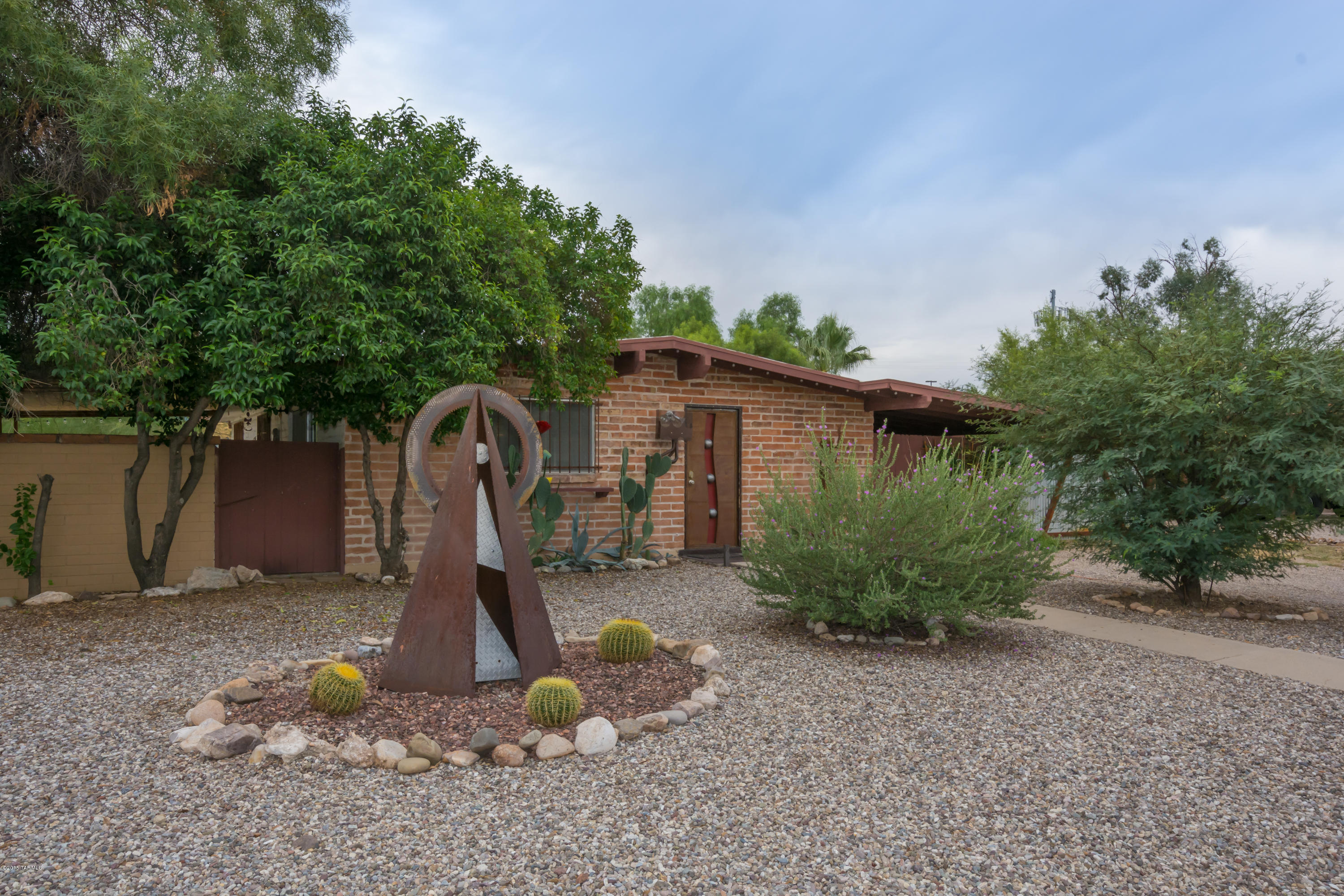 Burnt adobe beauty!  3 bedroom, 2 baths, on a HUGE OVER SIZED PRIVATE LOT!
Park all your toys behind a tall wall.  Wonderful rolling gate, big 20 x 30 workshop with 220V. Perfect for additional garage space, mechanics or wood shop even an art studio.  Such possibilities. Great central location.  North South orientation. Pool, lots of yard and mature trees.  Vaulted ceiling, skylight in kitchen and wood floors in living room and kitchen.  Open floor plan, charming place for kitchen nook and slider out to covered patio.  New electrical, newer AC just serviced.  A cute place to call home.