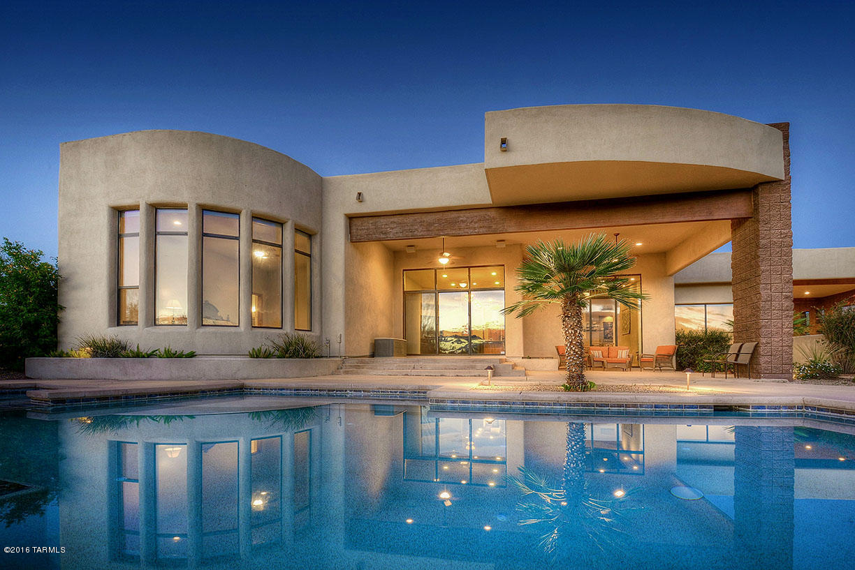 Beautiful architectural design that emphasizes quality of materials & makes the most of beautiful sweeping views from a stunning 2 acre lot in the Tucson Mountains within exclusive Gated Saguaro Cliffs; interior features include solid alder doors, warm travertine stone flooring, entertainers kitchen with generous seating bar, gleaming granite counters & top notch appliances.  Casual yet elegant living areas with dual fireplace and windows galore that frame lovely views all around.  Spectacular pool/spa, deep covered porch for outdoor dining & relaxation, and great yard space.  Garage has bonus exercise space or storage/workroom NOT included in sqft.  It's a sanctuary,but still so very close to Downtown, UofA, Raytheon, Catepillar's future site, shopping, Star Pass, hiking & biking trails