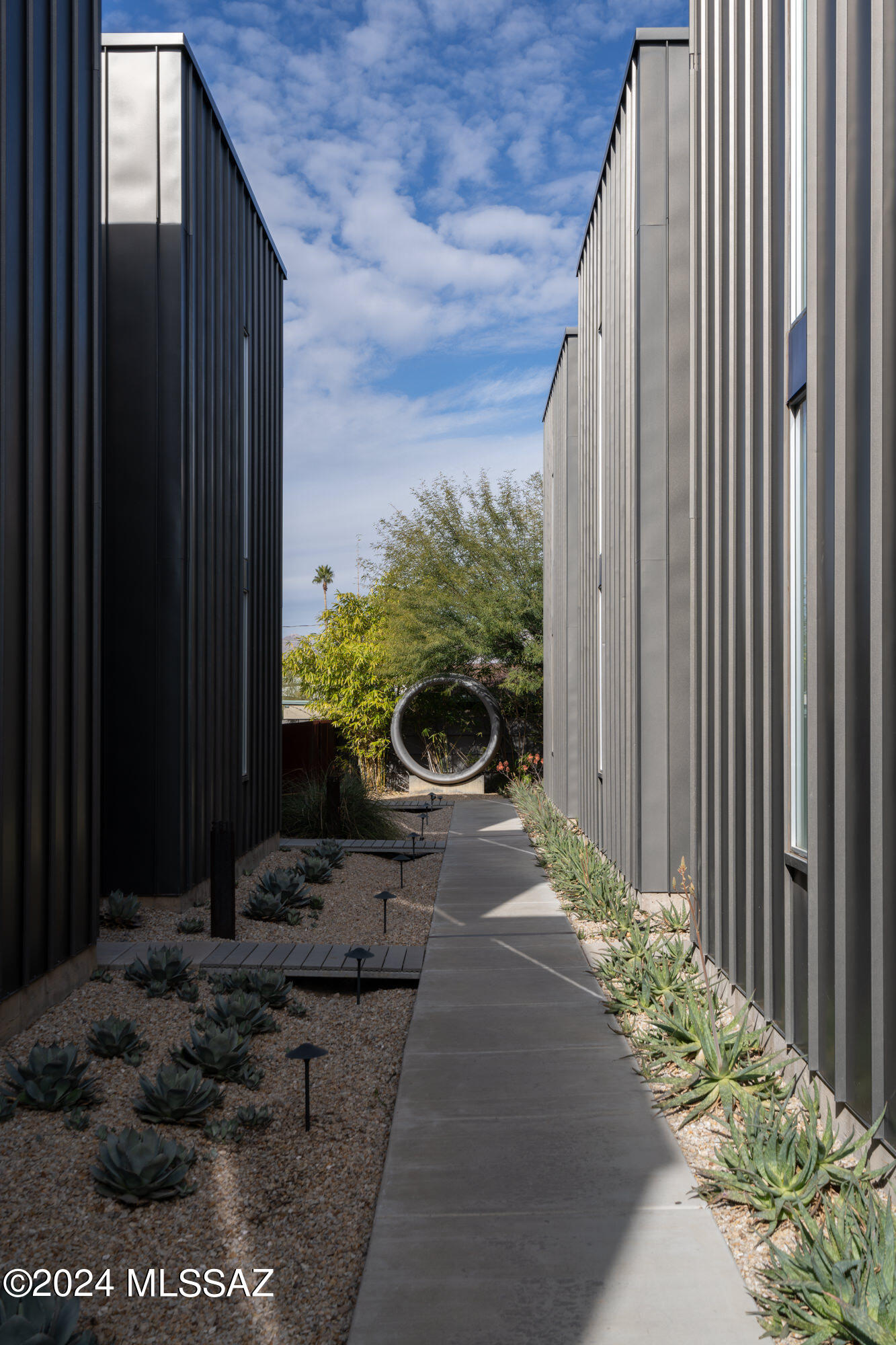 Welcome to Indigo Modern, an award winning infill project designed by Architect Rob Paulus. This 11-unit town loft redefines community living with its central location, just moments away from shopping, restaurants, and the University of Arizona. Every detail has been considered to create a harmonious blend of style and functionality. The energy-efficient design seamlessly integrates indoor & outdoor with clean lines and a modern aesthetic. Strategically positioned windows invite the serenity of the private courtyard and the expansive desert sky into your living space, while the upstairs private balcony offers unobstructed views of the majestic Catalina Mountains.  This 1,800 SF, 2 bedroom, 2 bath unit is setback from 3rd and the parking area, offering privacy and protection.