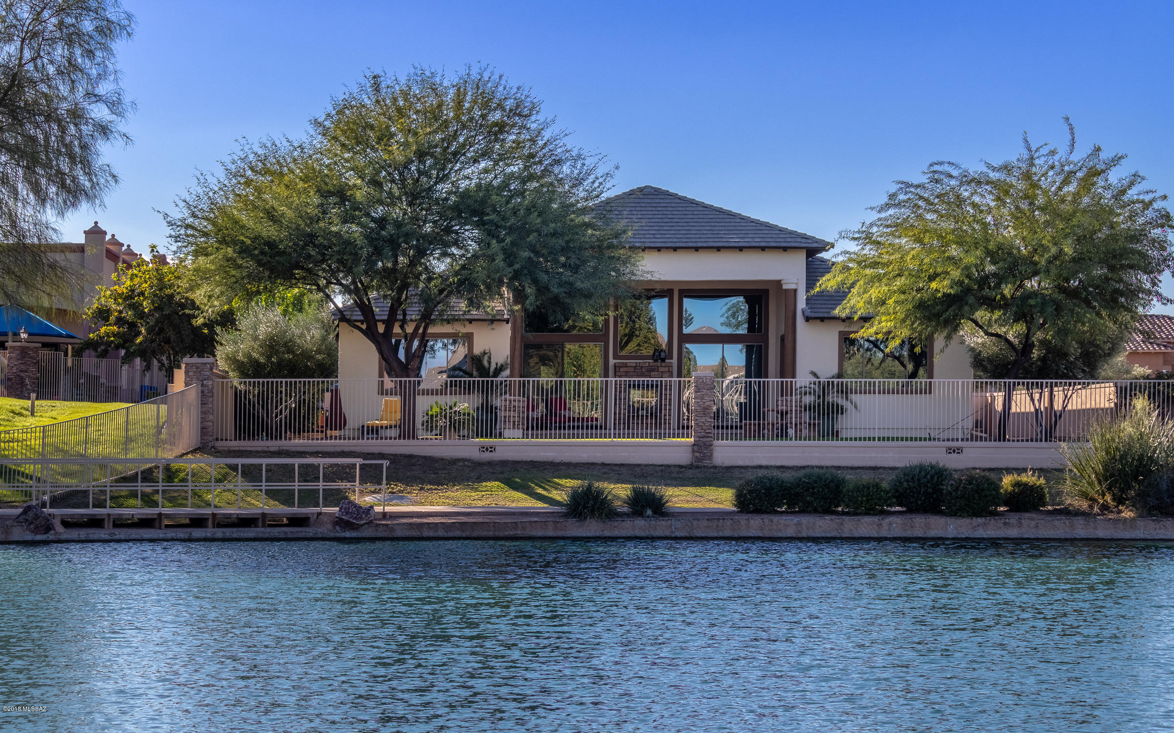 What's better than desert living, in a custom home, on A LAKE?  NOTHING!!  This 4 bedroom, 4 bath home will check all of your boxes while captivating your heart with the tranquility of its surroundings.   The home has cathedral ceilings in the main room, with an open & split floor plan, a see-through fire place nestled in a wall of windows over-looking the lake, custom kitchen cabinets made from Mesquite Wood & glass, granite counters, Thermador Appliances, under-counter lighting, Italian Porcelain Tile, All bathrooms have Mesquite Wood & granite to match the kitchen, Low-E Windows, over-sized 4-car garage w/all LED lighting, built-in garage shelving & epoxy flooring, 4-person hot tub, paver-drive way & pavers throughout front & back yards, the UPGRADE LIST IS TOO LONG, see attachment!