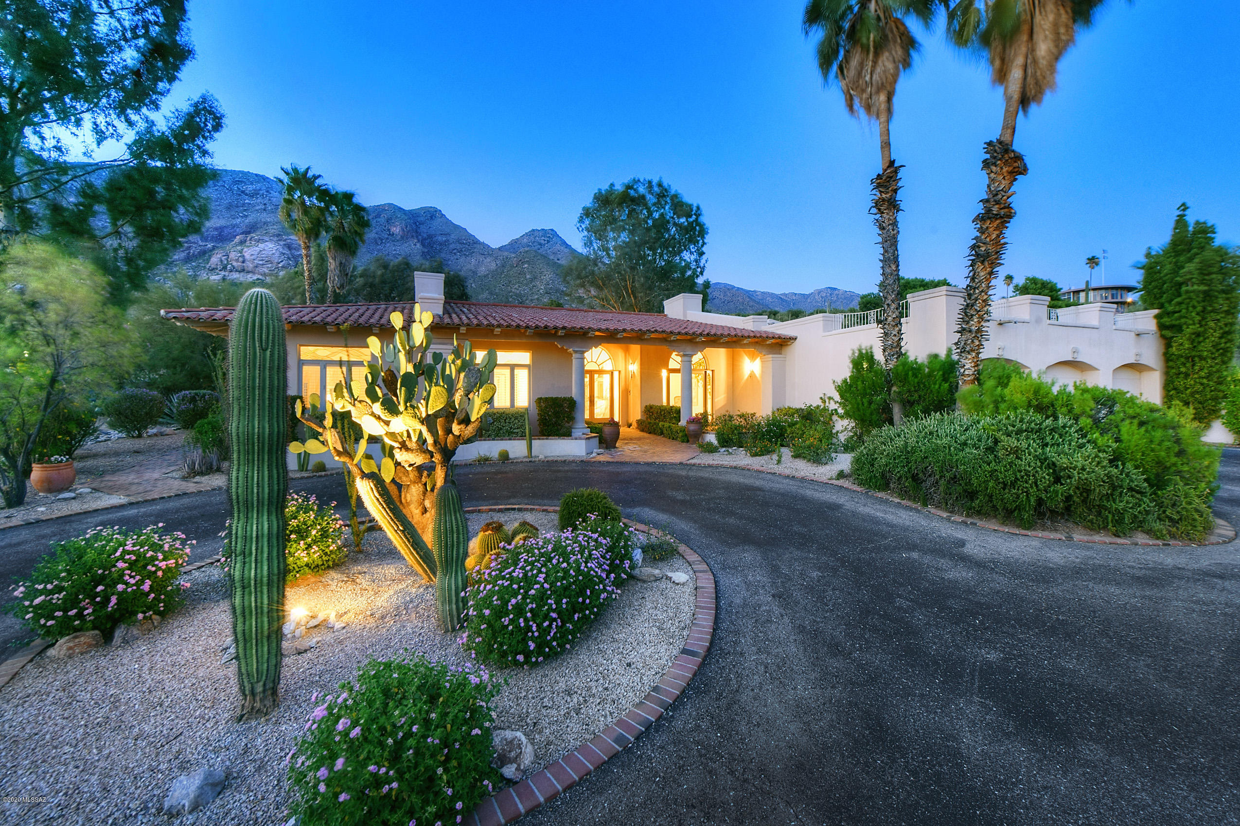 With an air of Old Hollywood elegance, mingled with classic Southwestern charm, this meticulously detailed Howard Curtin custom home with picturesque views is a prized find in prestigious Skyline Country Club Estates! Timeless architectural beauty, winsome character, and gracious appointments highlight this exquisite home replete with generous, light-filled living spaces. The beautifully composed single-story, split-bedroom floor plan offers wonderful privacy for family and guests. Having no steps within the house make this the perfect place to enjoy living the fabulous Foothills lifestyle for a lifetime! The tranquil front terrace that welcomes you from the start also offers enchanting skyline views of the Tucson Valley. Stained-glass double entry doors open into an elegant foyer, featuring luxurious marble flooring and impressive views of both indoor and outdoor space. The open formal living room is framed by a trio of French doors that flood the room with gorgeous, natural light. A magnificent four-sided white coral fireplace is the show stopping focal point! The adjoining great room is accented by soaring, wood-beamed ceilings and arched picture windows framing dramatic views of the Santa Catalina mountains. Another set of French doors offer seamless indoor-outdoor transition to the serene private patio.  The flowing Spanish-style fountain makes this patio the perfect place to entertain or just relax and enjoy the breathtaking views! Lending to an easy flow is the voluminous chef's kitchen, perfectly situated for both casual and formal entertaining and easy day-to-day living. A door leading to the pool area makes outdoor entertainment a breeze! Featuring a cozy breakfast nook, expansive custom cabinetry, a butcher block-topped island and a walk-in pantry, you'll find plenty of storage and well-designed work space. The adjoining elegant, formal dining room with fine dining ambience is sure to impress! Accented by French doors opening to an intimate, private terrace, this room offers stunning skyline views by day and twinkling city lights by night. An elegant masterpiece, the owner's suite offers both privacy and luxury! Featuring a kiva fireplace, sitting area, and sprawling bedroom space, this is the perfect place to relax and unwind. Two sets of French doors allow access to two separate outdoor patios. The first of two ensuite bathrooms, the larger one features a lavish soaking tub and private, indoor spa, along with outdoor access to the pool area. The second features a large walk-in shower. Connecting the two bathrooms is an expansive walk-in closet.

The three additional bedrooms are at the opposite end of the house, offering maximum privacy.  A spacious bedroom with private ensuite bath and patio access is a welcome space for guests, while a shared Jack-and-Jill bathroom offers a convenient layout for the remaining two bedrooms. The space is completed with an adjoining library/den/bonus room/home office option with private entry. The exceptional indoor and outdoor spaces make this a one of a kind home! Spend tranquil Sonoran desert days relaxing in the custom-designed swimming pool with the rugged mountains in view, or retreat under the ramada and enjoy the spacious privacy the golf course provides. This location embodies the finest living that Skyline Country Club Estates has to offer!