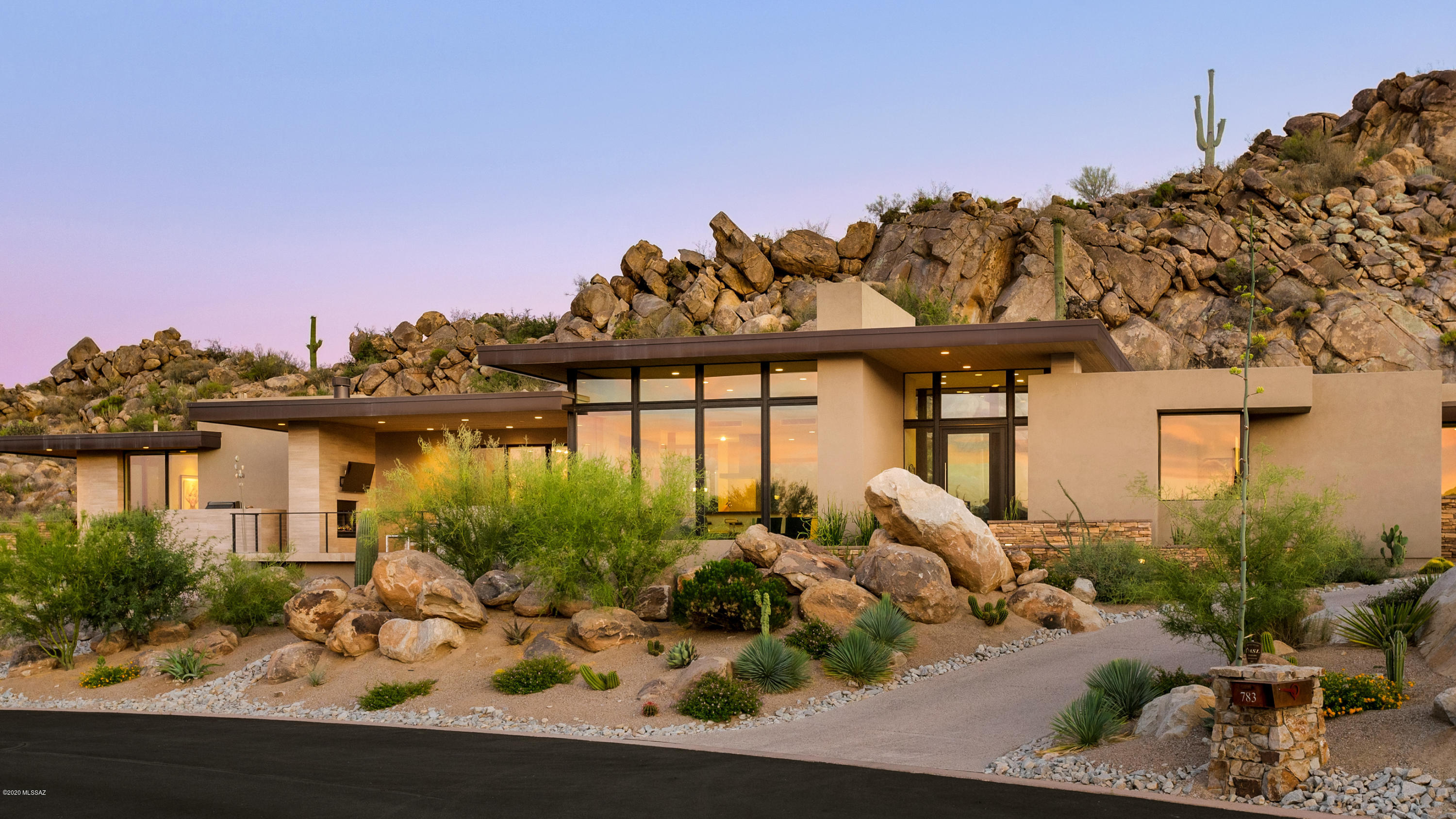 Contemporary excellence awaits you at this premier 2018 Kevin B. Howard designed home. This exquisite homesite is set amongst the unique surroundings that only Stone Canyon can provide.   Artfully placed on a private 1.15 acre lot providing a proper balance of sun and shade with stunning natural rock formations that you can enjoy from every window in the house. Take in the beauty from the moment you walk through the grand entry!  The main living space allows for easy entertaining with floor to ceiling windows, fireplace and art niches. A Control 4 automation system simplifies whole home audio and flows perfectly into the kitchen and dining area.  Italian Poliform cabinetry and Silestone counters provide a sophisticated and exceptionally functional kitchen. High end kitchen finishes include seamless built ins, soft close drawers/cabinets, wine fridge, individual refrigerator/freezer units, and an appliance garage. Top of the line Miele appliances, double ovens and a chefs cook top at the island allow for the ultimate cooking experience. The wet bar is also a popular spot with functional flow, cabinetry, built in Clear Ice Maker and AV wiring if desired. When ready to enjoy the outdoor space you have some amazing options! Enjoy the intimate back patio where the natural environment surrounds you in total privacy. The outdoor Sala provides al fresco dining, a pass through fireplace, entertainment area, open air kitchen plus a refreshing spool (sized between spa and pool) to be enjoyed year round. The sleeping quarters are on a split floor plan and all ensuite design for family and guest privacy. The large master suite feels like a 5 star experience with large windows, amazing views, generous walk in closet, separate tub/walk-in shower and private courtyard access. The office space is just off the master suite with built in desk, cabinetry and more outdoor beauty. Stone Canyon is a premier lifestyle and private golf community surrounded by the stone boulders in Oro Valley, AZ. This Phil Mickelson community offers sports membership or full private golf membership, health and fitness facility (exercise, tennis, lap pool, play pool, spa, massage, saunas) and extraordinary clubhouse. Visit their website for more information. **Be sure to check out the full video and utilize the virtual floor plan to walk through the home at your leisure.**