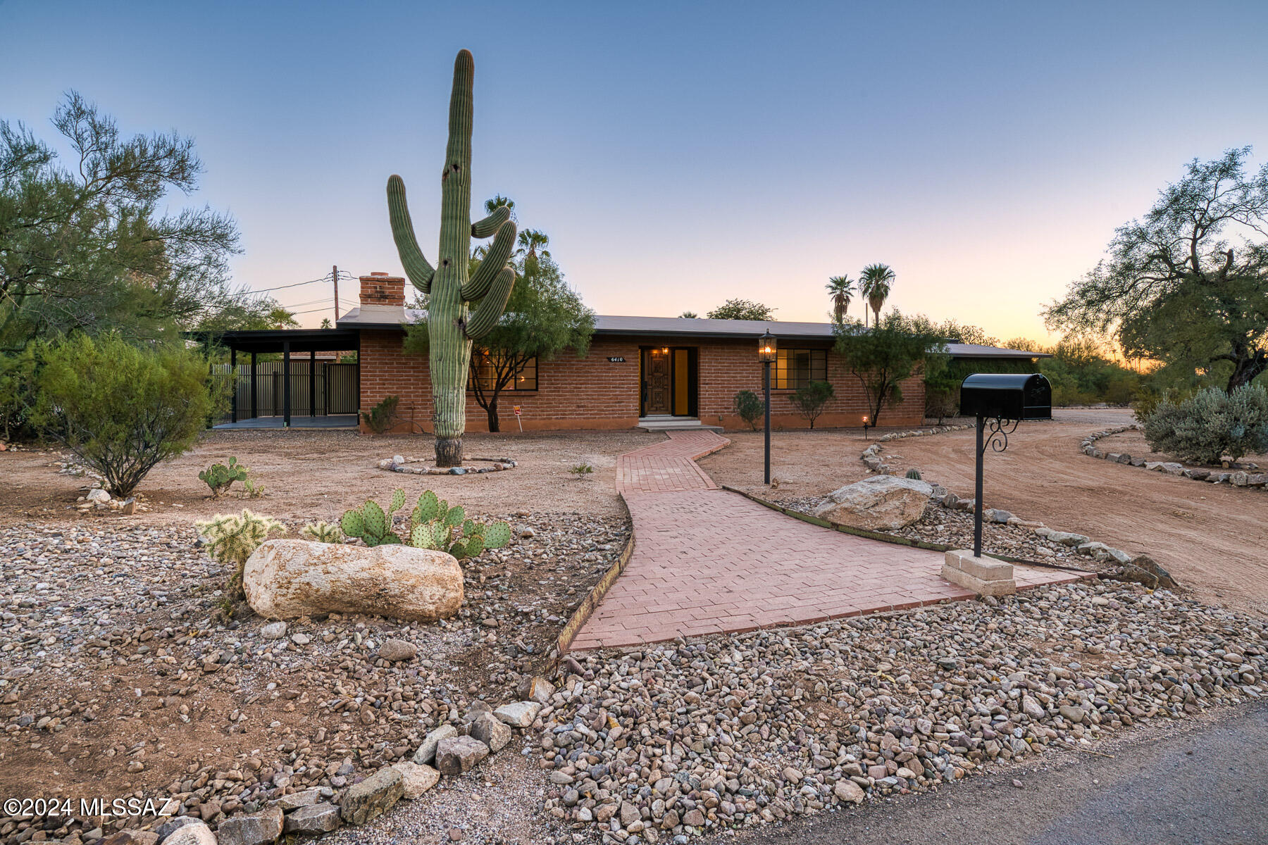 Quintessential Midcentury burnt adobe brick home, originally designed by Maxon/Smith as a desert hideaway. The low profile & straight lines of the ranch design juxtaposed w/ the vast natural desert lot gives a unique sense of comfort in the home. All rooms were built to be generous in proportions. Living room, dining room & kitchen blend seamlessly perfect for entertaining inside & out. 2 bedrooms both w/ ensuite baths, large closets, & fully outfitted laundry room allows for modern comforts. Two additional storage rooms in oversized 2 car carport provide plenty of storage. Backyard is simple & private with a long covered porch. Property is contributing to Historic Harold Bell Wright Estates & may be eligible for reduced property taxes. Listing Broker has financial interest in property.