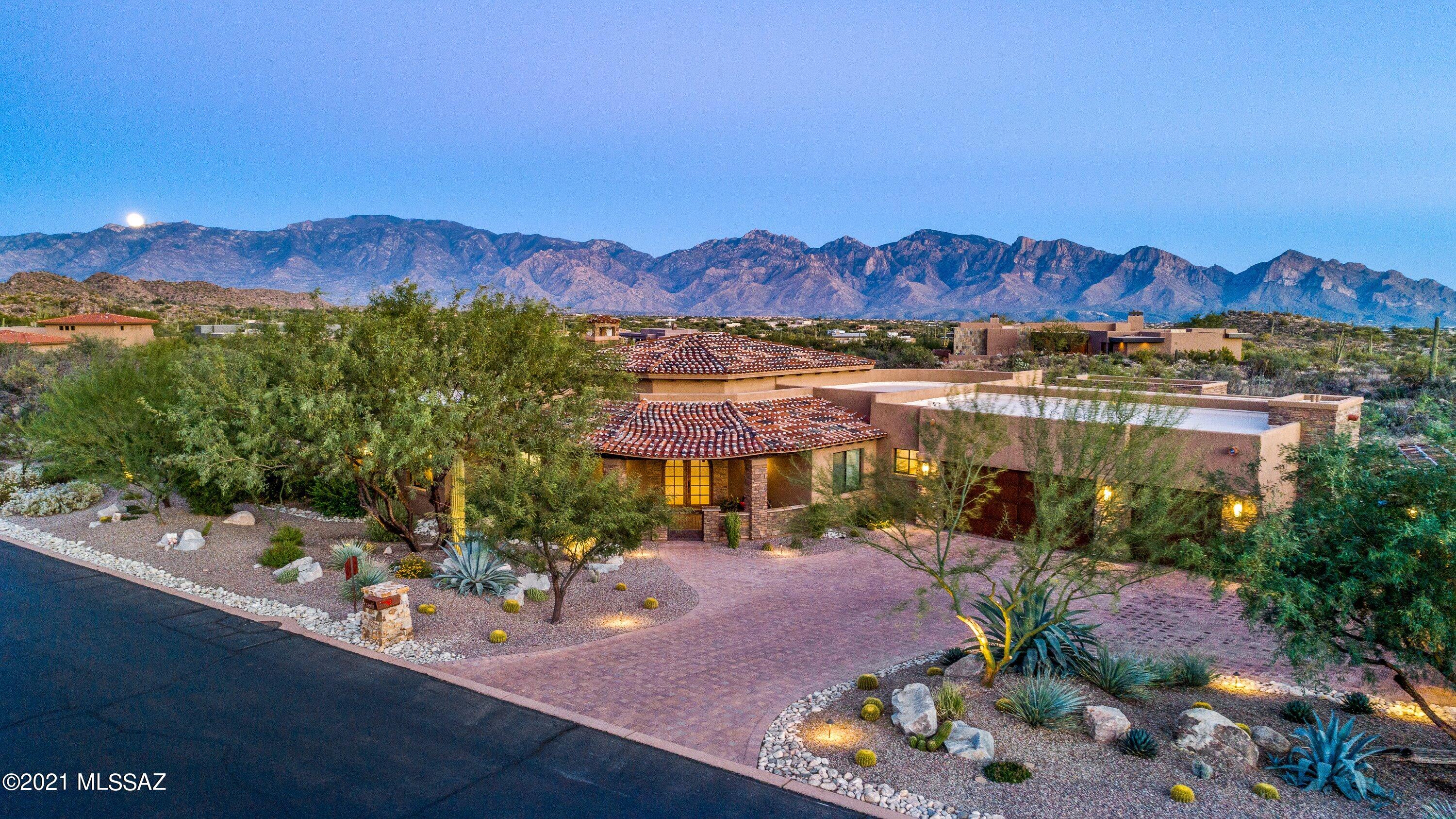 Tuscan lifestyle with modern amenities featuring rooms with a variation in ceiling heights, including the spacious Great Room providing Catalina Mountain views, an adjacent cook's kitchen and nook which define the casual areas where today's true living takes place. Separation between living and sleeping areas of four bedrooms with baths, formal dining room, spacious den, Travertine flooring throughout, 8' solid knotty alder doors, granite counters, Wolf and SubZero appliances, 3 large patios, outdoor BBQ, and a newly constructed sky deck offering views of the city lights. A large 3 car garage, plus a separate 2 car, 900 sq ft heated and cooled garage, exercise room or other.