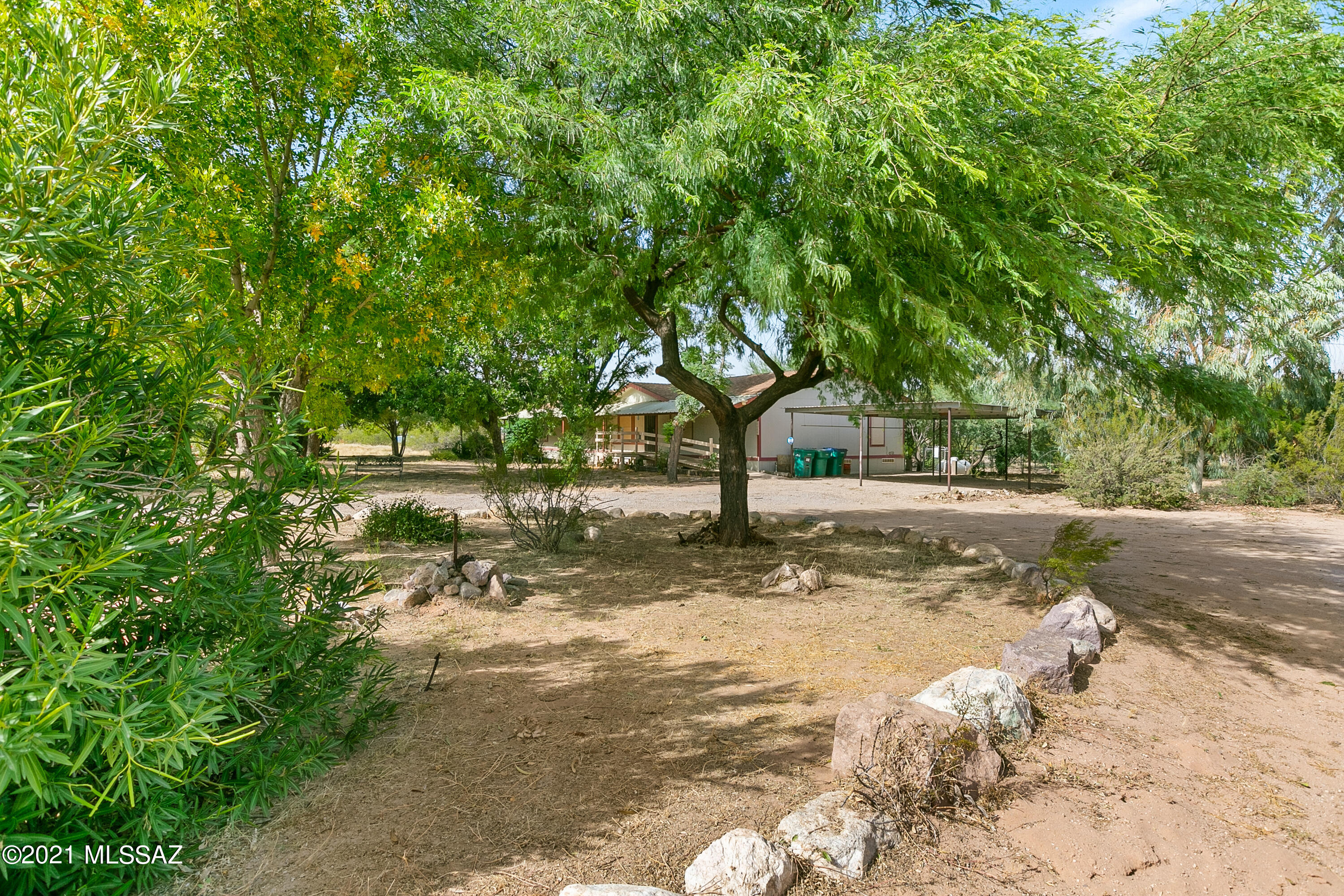 Large, over four acre lot with good sized four bedroom two bathroom manufactured home. Updated HVAC. Separate living, dining and family room off the kitchen. Plenty of room for everyone in the large kitchen with island, pantry closet and refrigerator. Split bedroom floorplan, Good size master suite with walk-in closet, separate shower and soaking tub. Seven car carport, five with concrete flooring. Attached storage or workshop of rear deck. Several additional sheds, plus RV parking. Several beautiful mature trees provide plenty of shade. Chain link fenced rear yard with separately fenced dog run. Horse facilities. Neat and tidy with neutral carpet, ceramic tile and laminate flooring.