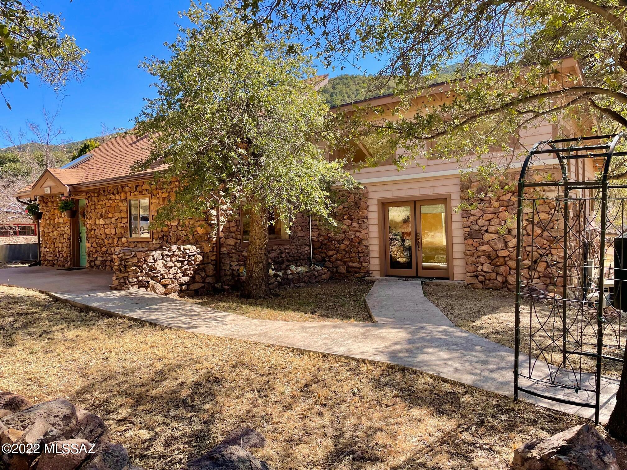 Check out this charming & cozy property just west of Old Bisbee on 31 acres in the Mule Mountains. Built in 1910 and updated since then, this well maintained and spacious 1-bdrm/1-bath stone cabin sits amid a pristine woodland landscape of animals, birds, oaks, and the seasonal Banning Creek running through it! There is a separate guest house, plenty of parking, and 3,600-gal water storage capacity for hauled water. Most acreage is unbuildable & mountainous. House is all-electric, stubbed for propane, has pine plank floors, is heated/cooled via fireplace, ceiling fans and NEW mini splits, features high ceilings, skylights and clerestory windows. Easy access off Hwy 80. Prepare to be enchanted! There is a possibility of adding a well. Call agent for info. Buyer to verify facts/figures.