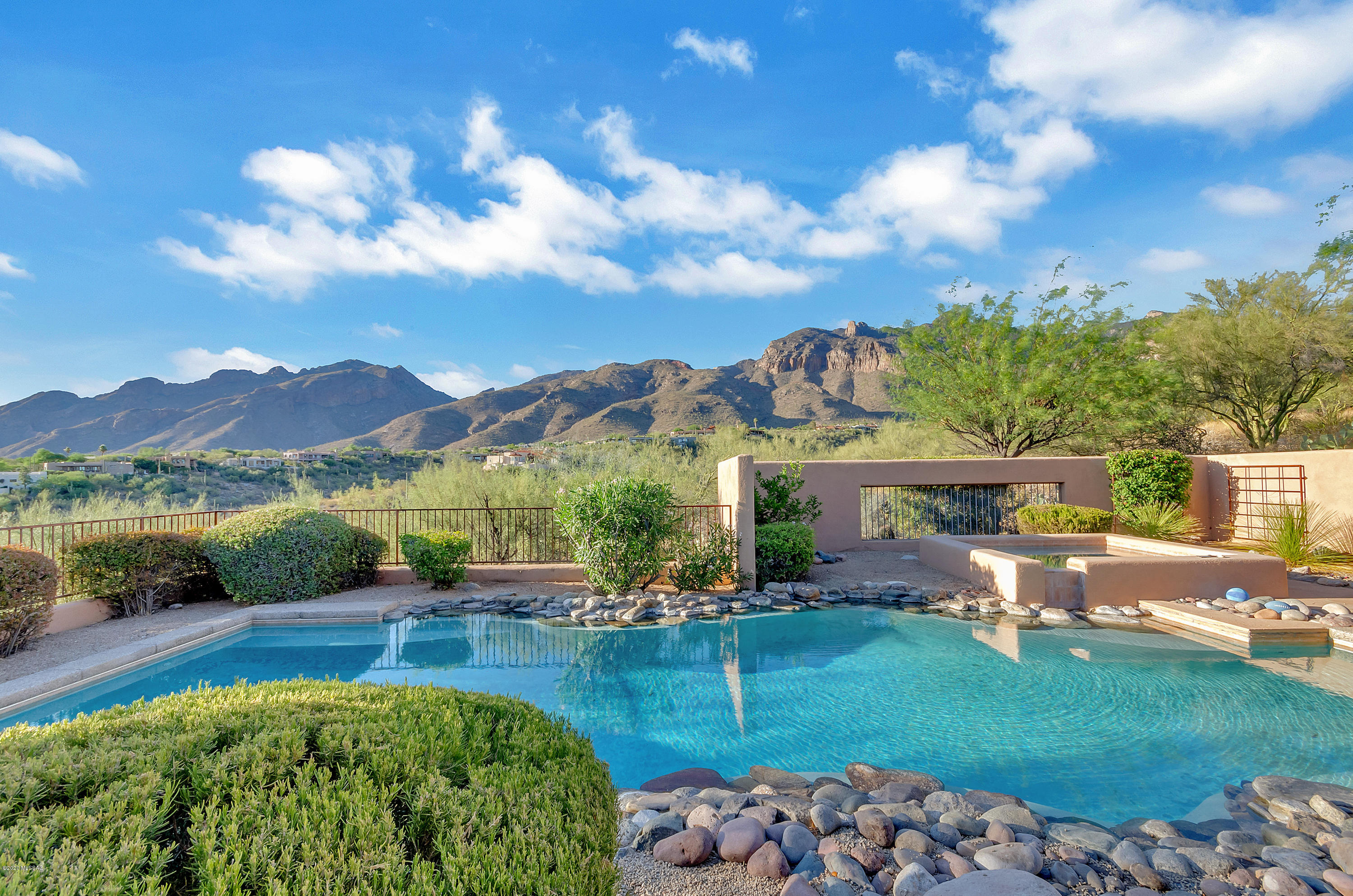 ''A little touch of the AZ Inn'' nested in the Catalina Foothills. CLASSIC Tucson charmer with extraordinary city & mountain views. This home is inviting, cozy and dreaming. 4 bedrooms plus a den/office, 4 bathrooms, 3 car + sparkling pool/spa. Amazing originality and style, combines with new modern upgrades and finishes. Beautiful natural landscaping, spacious outdoor patio, off family room, off kitchen, and another off the master bedroom, that is perfect for relaxation, lounging, and great for entertaining family and friends. Spa like setting surround with the best views Tucson has to offer. Situated on a high and very private lot. This house is in the most desirable location. Close to La Encantada, great schools, restaurants and all the cool attractions that the foothills has to offer. Newly designed circular driveway with pavers creates such a elegant curb appeal. Lovely courtyard welcomes your guest as they enter into this classy, beautifully designed custom home.