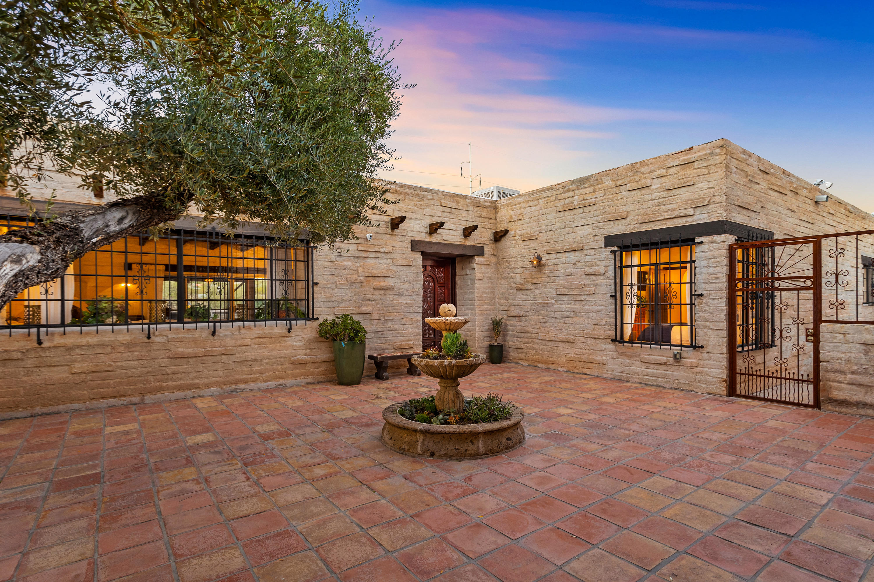 One-of-a-kind gorgeous estate on 3.3 acres in central Tucson, perched on the south bank of the Rillito River with panoramic mountain views from the north-facing yard. Enjoy the surprisingly rural feel of this property with its 3541 sqft home + 992 sqft casita built around a private central courtyard. Designed for the desert by Tucson architect and artist Warren Edminster, who rendered an old-world hacienda feel complete with Spanish accents, thick burnt adobe walls, high wood-beamed ceilings, fabulous custom built-ins and copper accents.  Fall in love with the custom Talavera and Saltillo tile throughout the home and plentiful natural light filtering in through the large windows and numerous skylights. 
Enter the front door to a charming gallery and turn into a spaciou great room with beehive fireplace, tiled plant shelves, tall ceilings and generous dining room. Proceed through a swinging door into a vast charming kitchen with new granite counters, a custom Talavera backsplash to complement the copper hood plus plenty of storage and room for a grand island.  
The master bedroom is a private oasis with a large custom walk-in closet, fully renovated bathroom and access to the backyard.  The main house features 2 private and spacious guest rooms with tiled window benches, large closets and an additional 1.5 baths for guests.
Built by Joe and Marian Tofel  founders of the Tucson Racquet Club (right next door!), this home is designed for entertaining and has hosted many of the great tennis stars throughout the years.  The Arizona room which spans the back of the home influenced the work of artist Marian who painted the majority of her oil and pastel paintings there.  With an abundance of natural light, and a beehive fireplace at one end, it's a truly inspirational space for creating and enjoying.  Beyond lies a large covered patio to gaze upon the mountain views. 
Completely separate from the main house, the large Casita offers two bedrooms, a common room, a kitchenette and full bathroom with access to both the courtyard and side yard. The tallest trees in the area attract a multitude of birds, including hawks and the occasional eagle. Offering direct access to The Loop for the cyclist, jogger or nature lover, with many of Tucson's best restaurants and shopping venues nearby.
Imagine the possibilities of living here  turn it into a family compound or rezone and split into smaller parcels - with this prime location and view, the possibilities are endless!