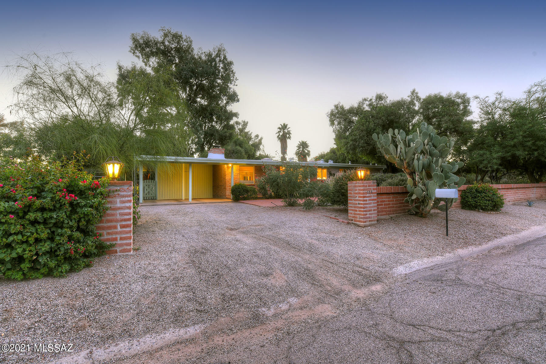 Beautiful mid-century Lusk home in Historic San Rafael Estates. This 2221 sq foot burnt adobe gem features plank and beamed exposed pickled wood ceilings, brick walls &  fireplace in formal living room with dining area. Upgraded kitchen w/new gas range opens to a large breakfast room and Den with 2nd fireplace which can be used as a 4th bedroom. 2 bedrooms share a full bathroom & the master has an ensuite bath.  Large Arizona room opens to a lush backyard with brick pavers, mature trees. Separate garden spot!  Dual cooling. A Basketball court, Double carport and additional storage. This home is on the national historic register which provides lower taxes for owner occupants! Community Pool!
