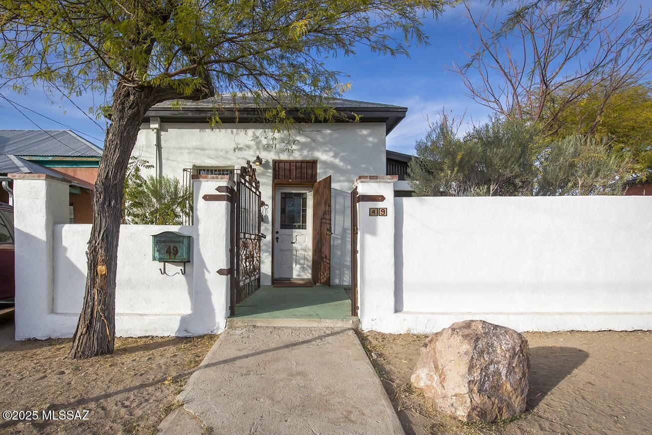 Absolutely gorgeous Spanish Colonial Revival adobe home in Barrio Libre, built circa 1896.  (Earliest recorded map is 1901, so likely the home was built between 1896 and 1901) Property is the very definition of ''rare treasure'' with thick adobe walls, spacious rooms, soaring ceilings, a wonderful eclectic collection of antique doors & fixtures and modern amenities.  Mini-splits heating & cooling.  Enclosed porch for al fresco dining, and yards have mature landscaping and are walled front, side, and back for ultimate privacy.    Includes a lovely full guesthouse, built in 2007, with an Asian flair, glass and exposed beams to which tall corrugated driveway gate provides ease of private access.  Offstreet parking is the deep driveway east of the house. NOTE: cameras recording audio and vide